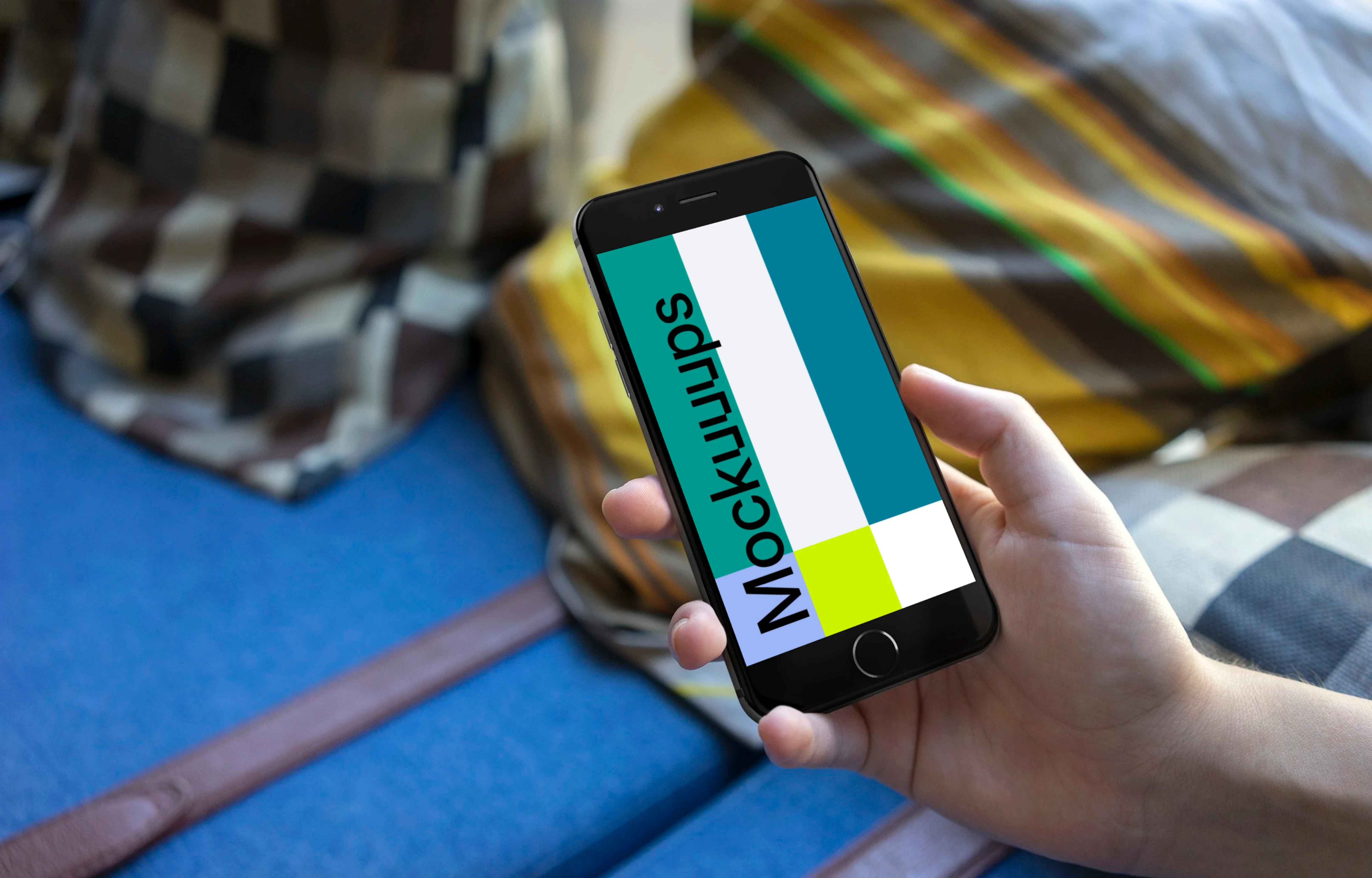 Holding iPhone 6s mockup on a Sofa with Pillows