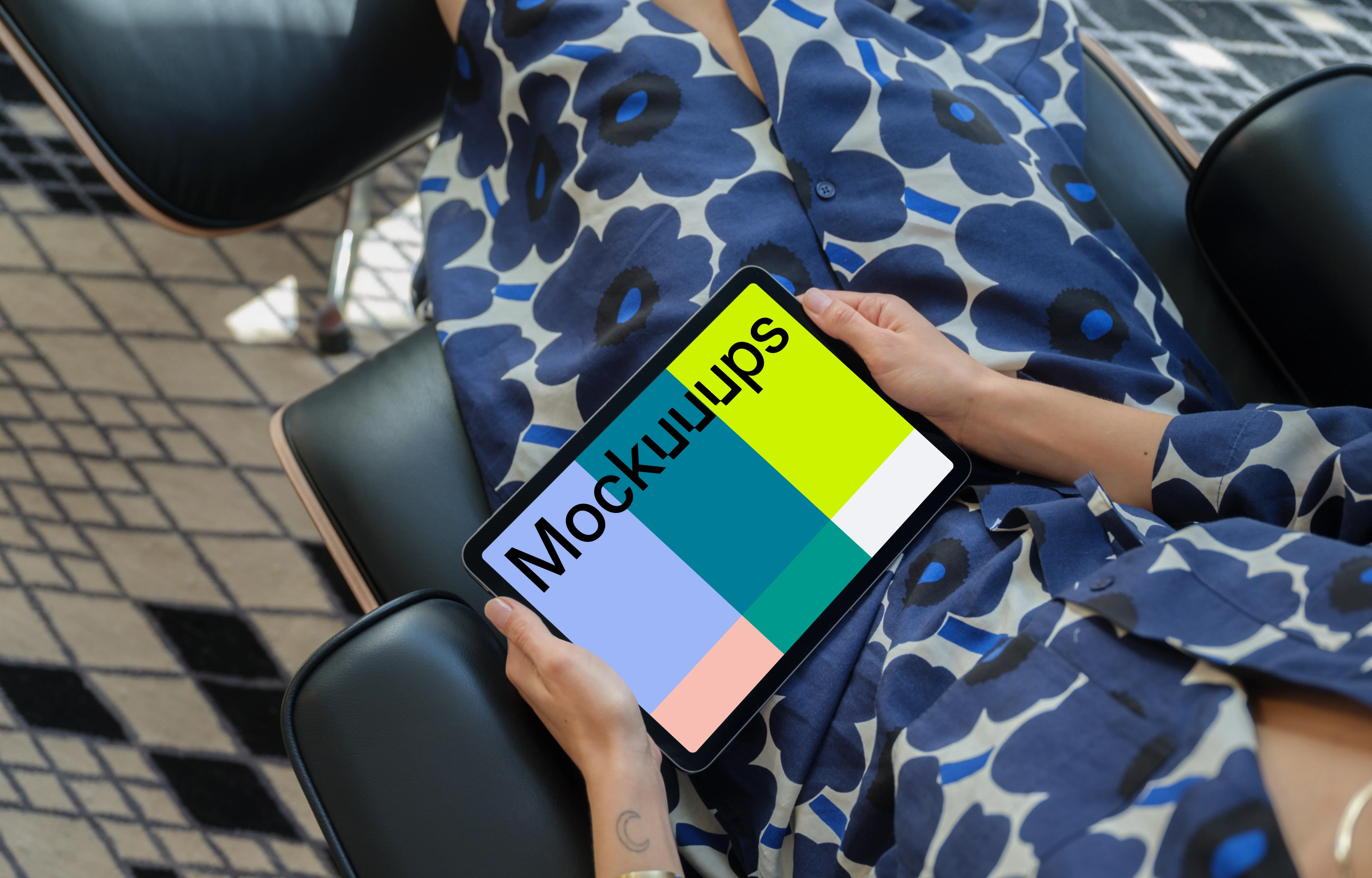 iPad Air mockup in a woman's hand on a modern chair