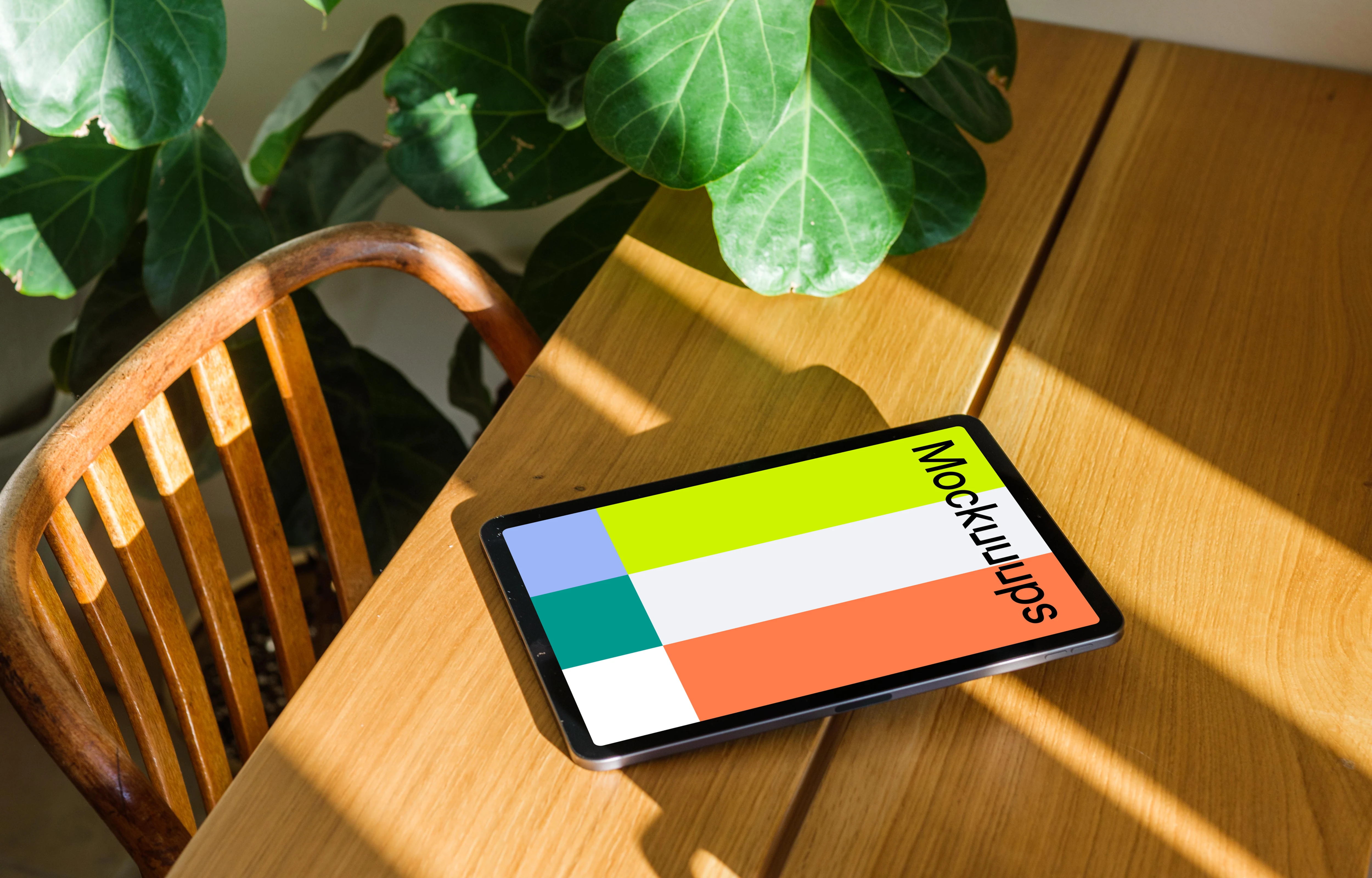 iPad Air mockup on a wooden table beside a plant