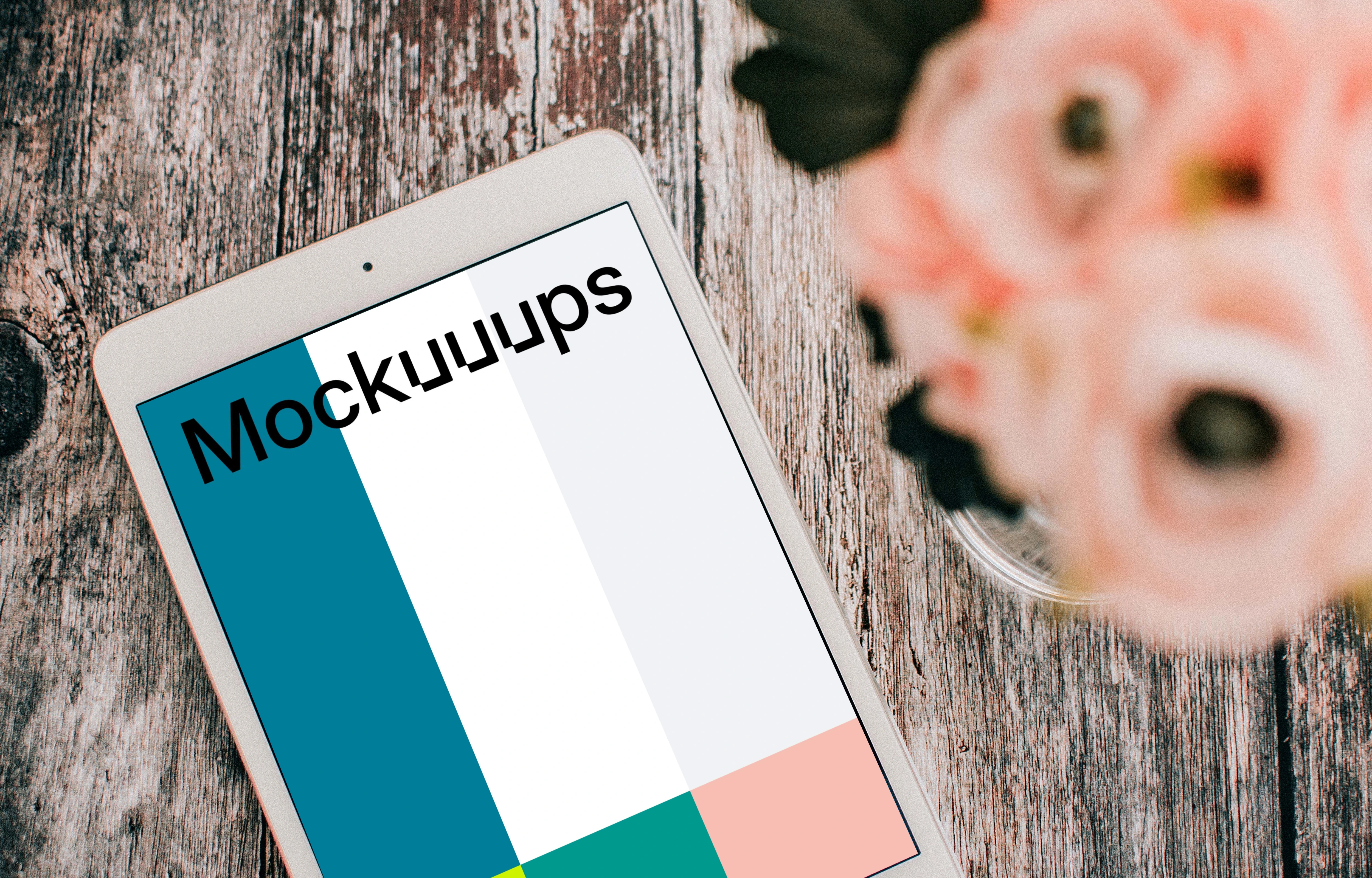 iPad Mini mockup a brown table beside a vase of roses