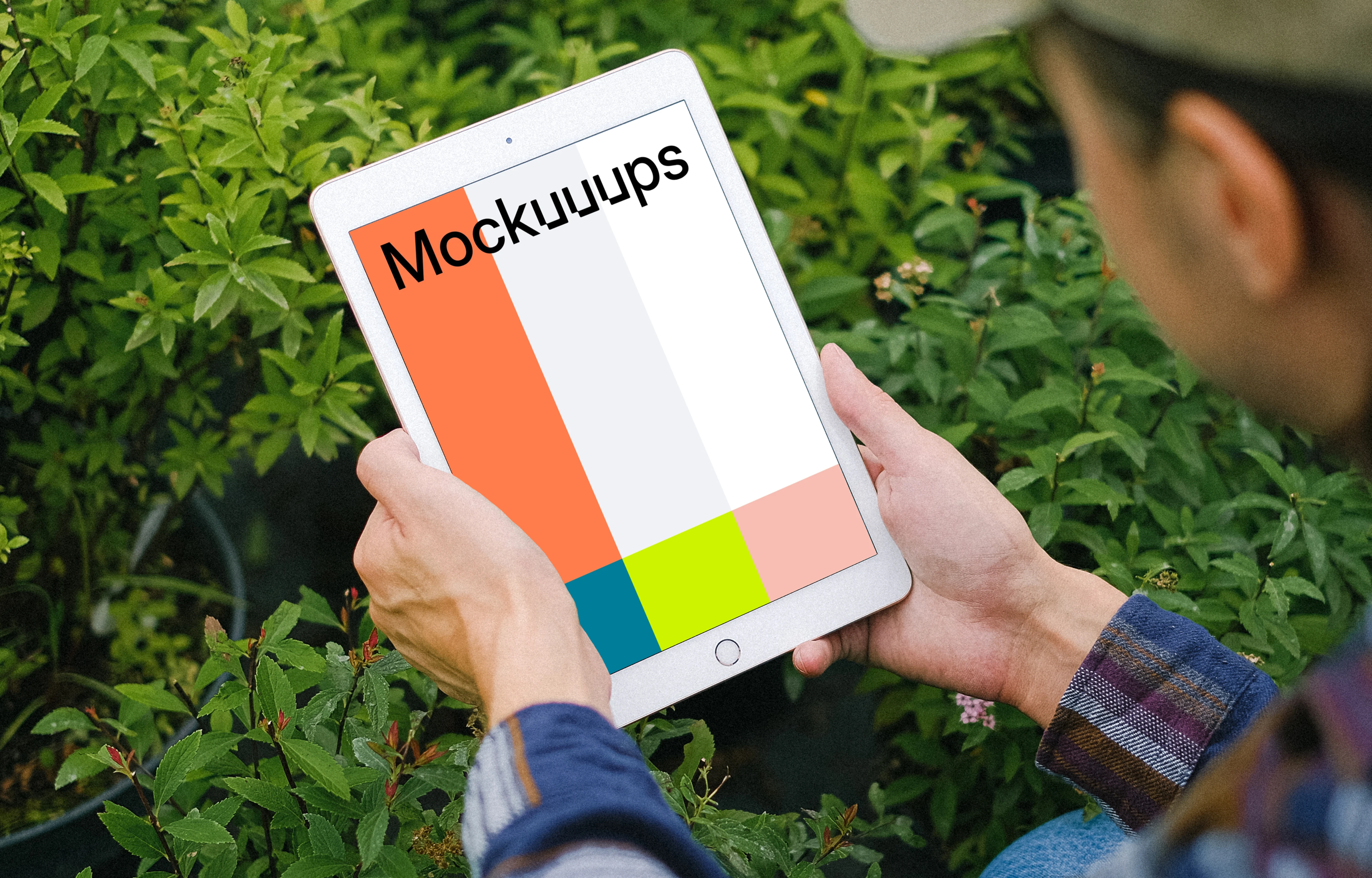 iPad Mini mockup held by male user in a garden.