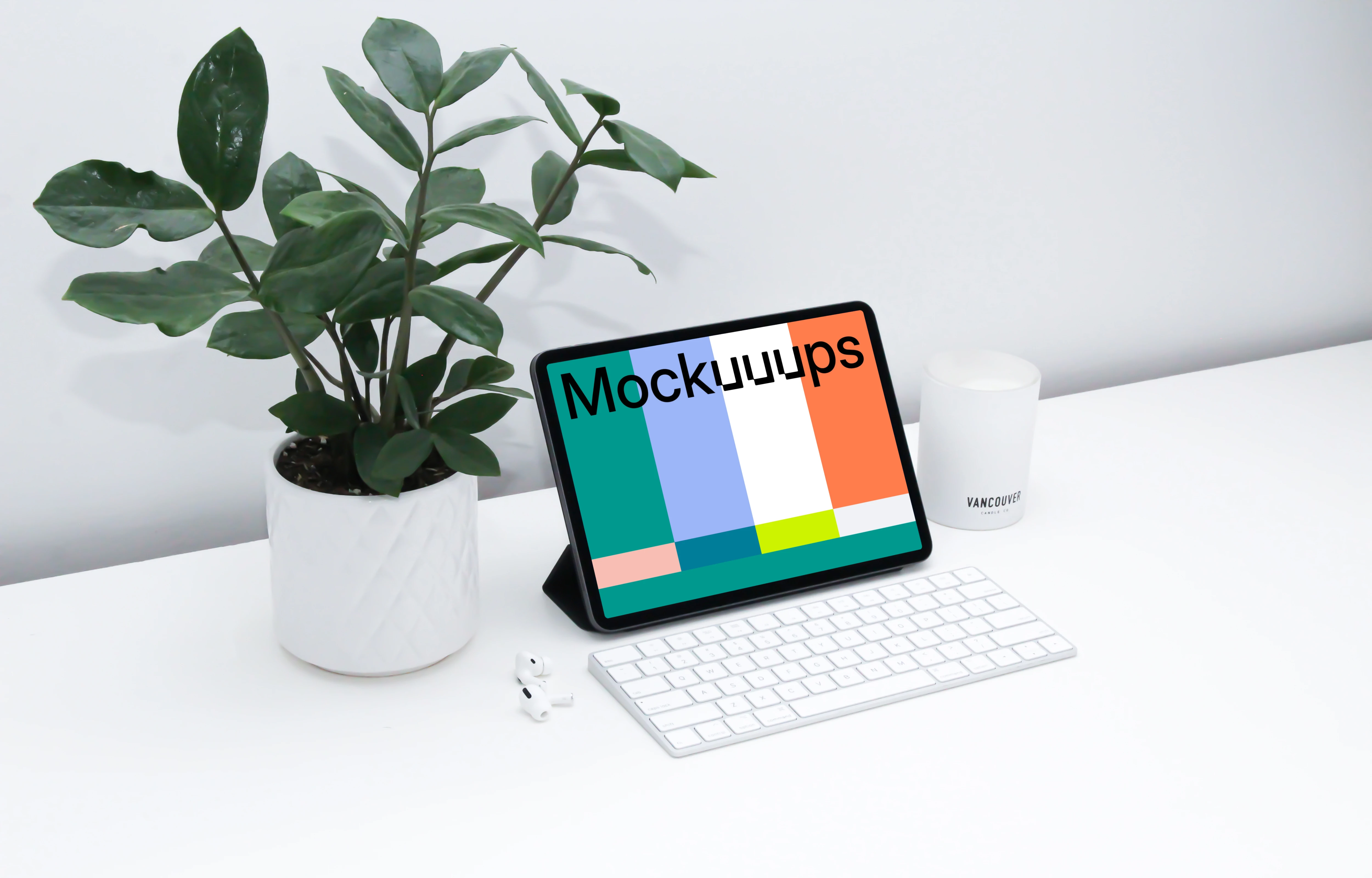 iPad mockup on a white table beside Airpods Pro