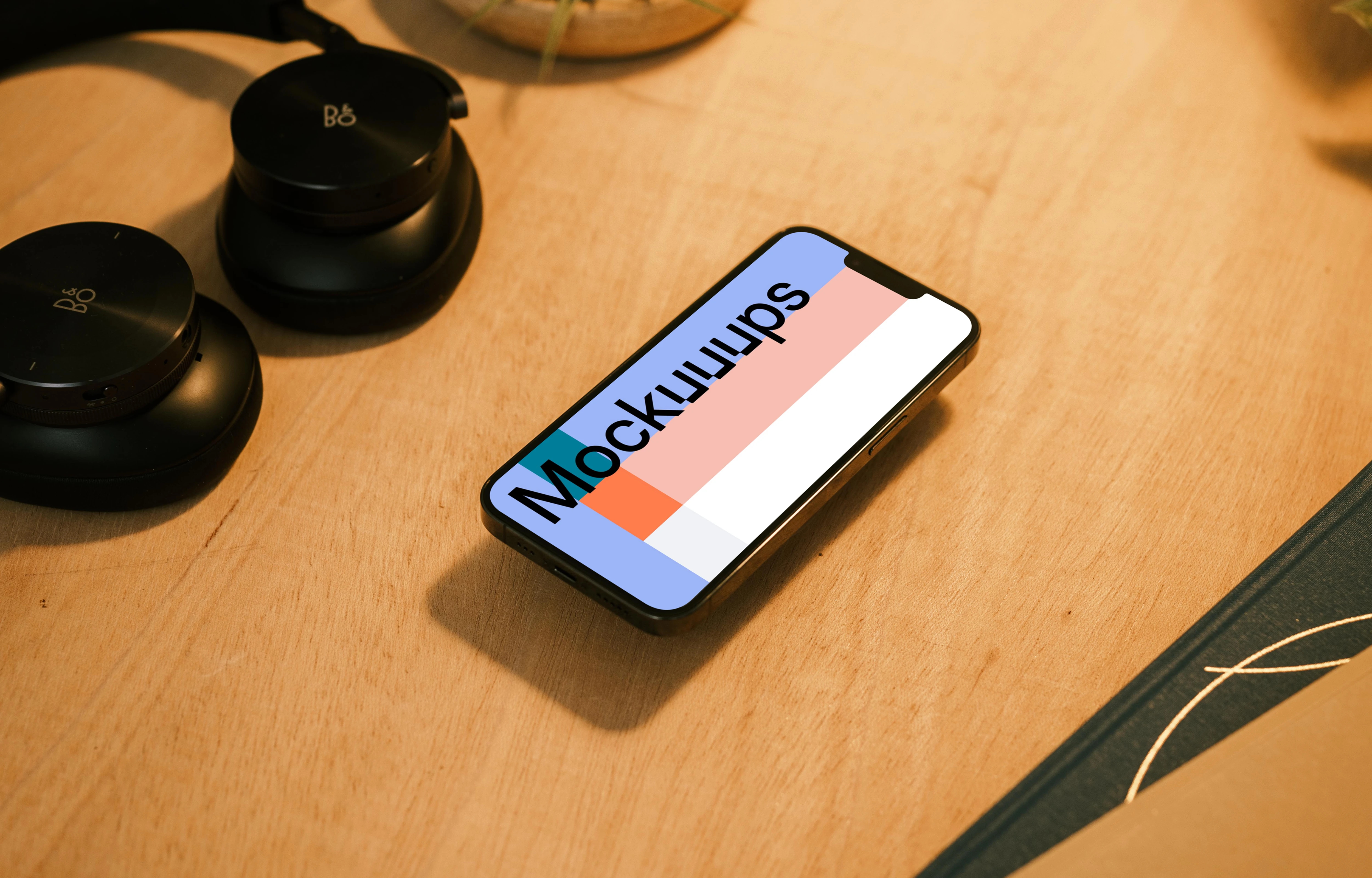 iPhone 13 Pro mockup with a pair of headphones at the side