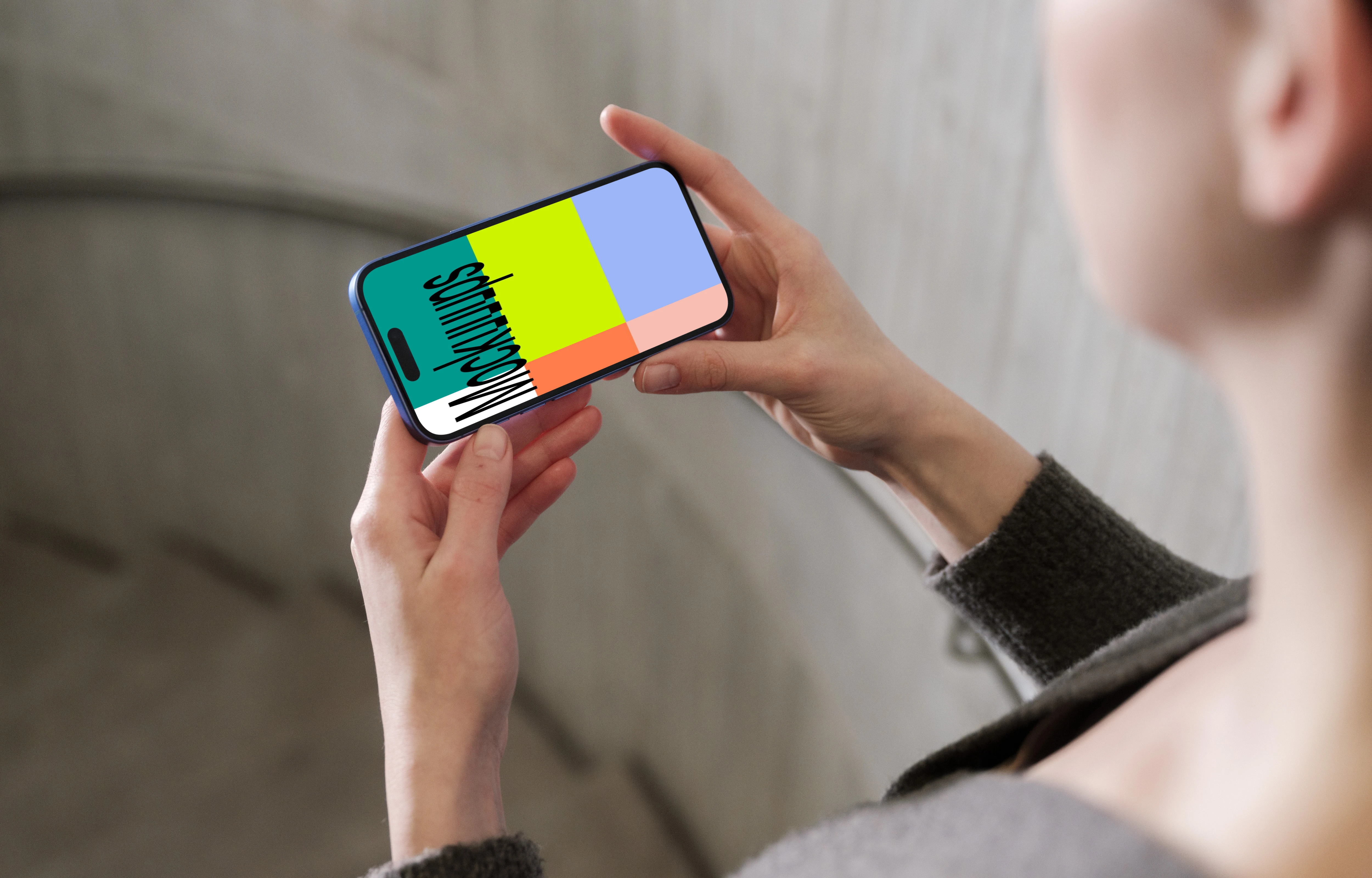 iPhone 16 mockup in a hand against concrete backdrop