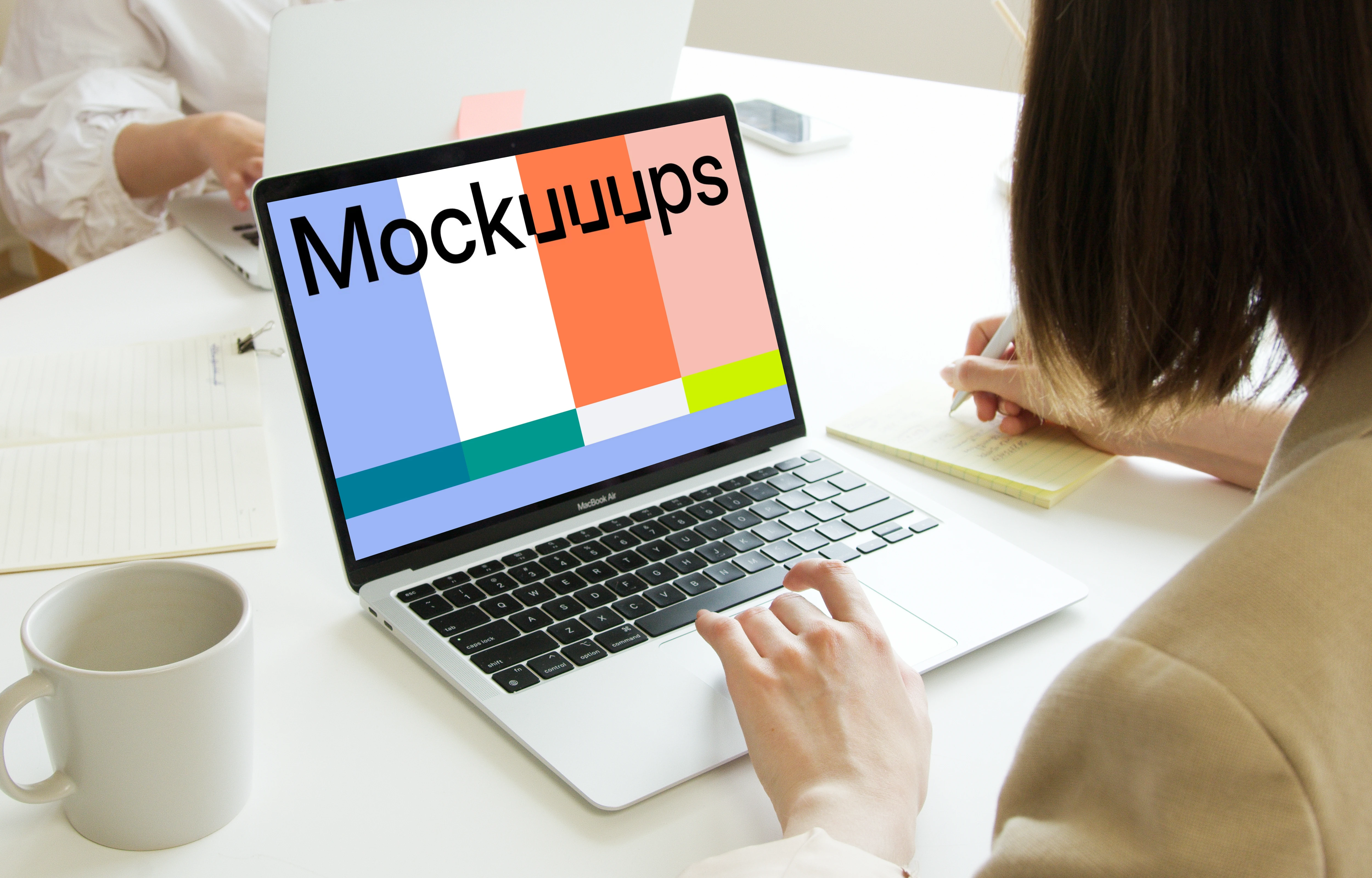 Lady using a MacBook Pro mockup and writing in a notepad