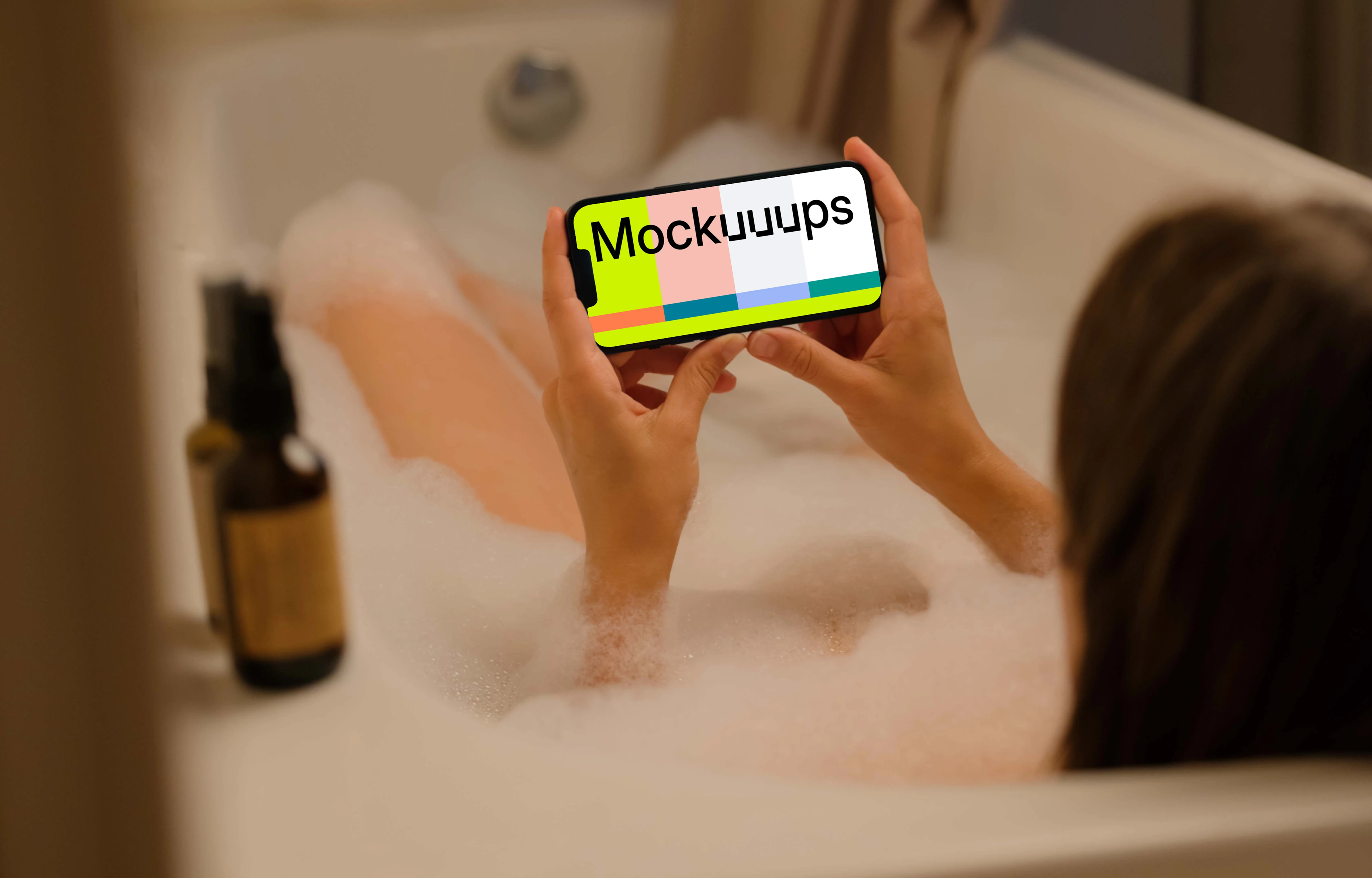 Woman in bath holding an iPhone 13 mockup