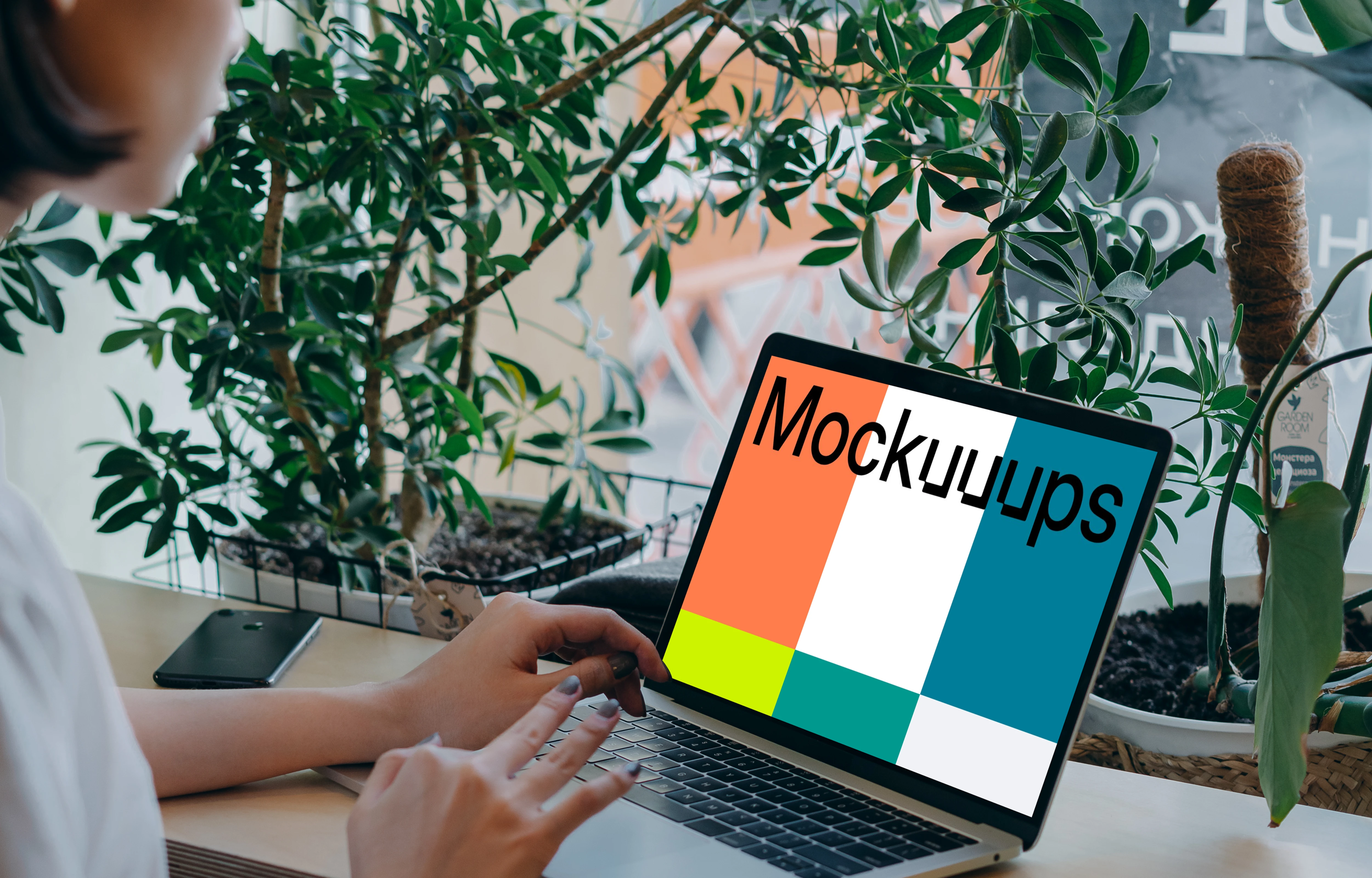 MacBook Air mockup in use by a lady with a lot of plants in the background