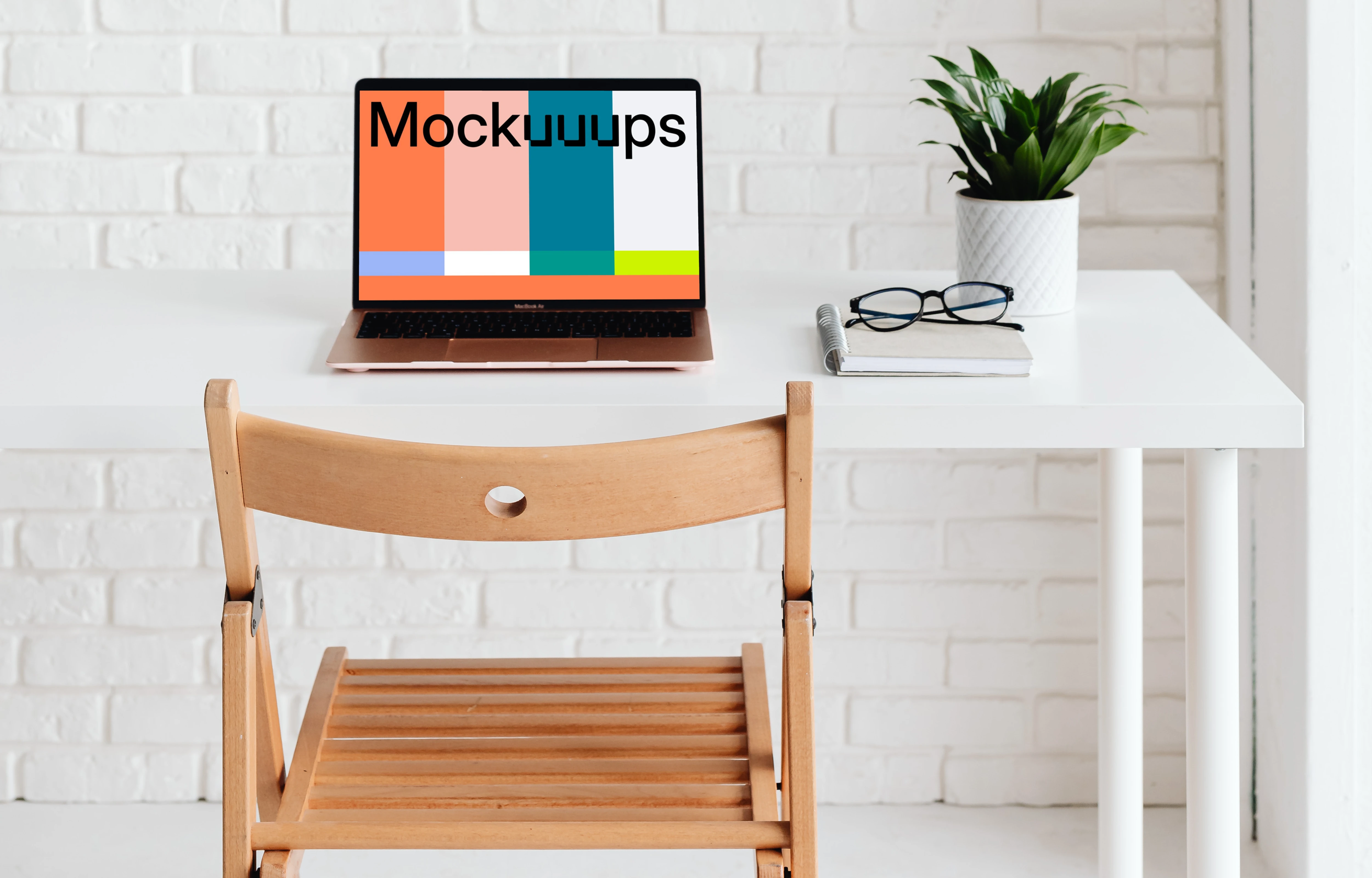 MacBook Air mockup with a notebook and pair of glasses at the side