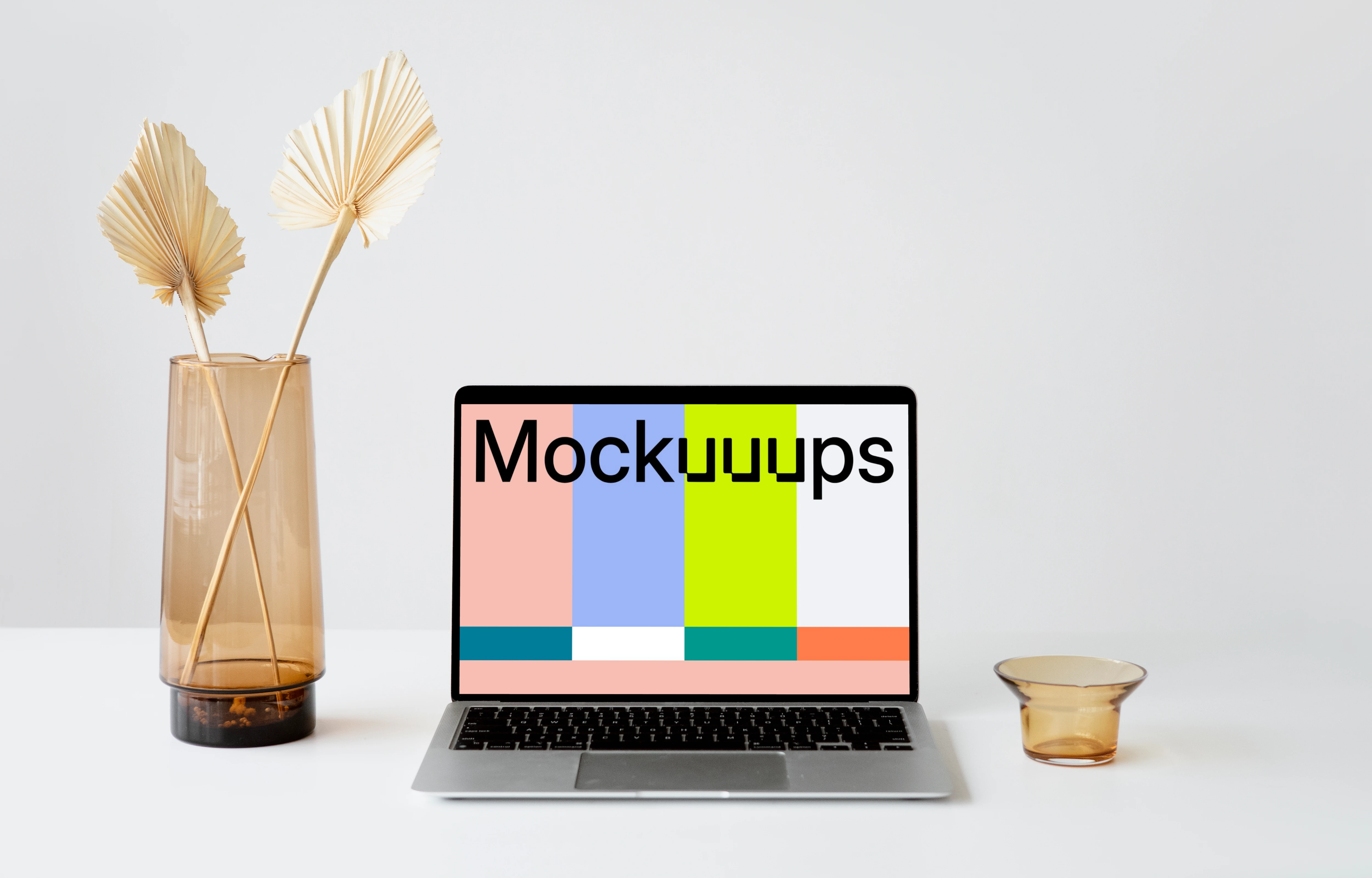 MacBook mockup on a white table with fancy flower vase at the side