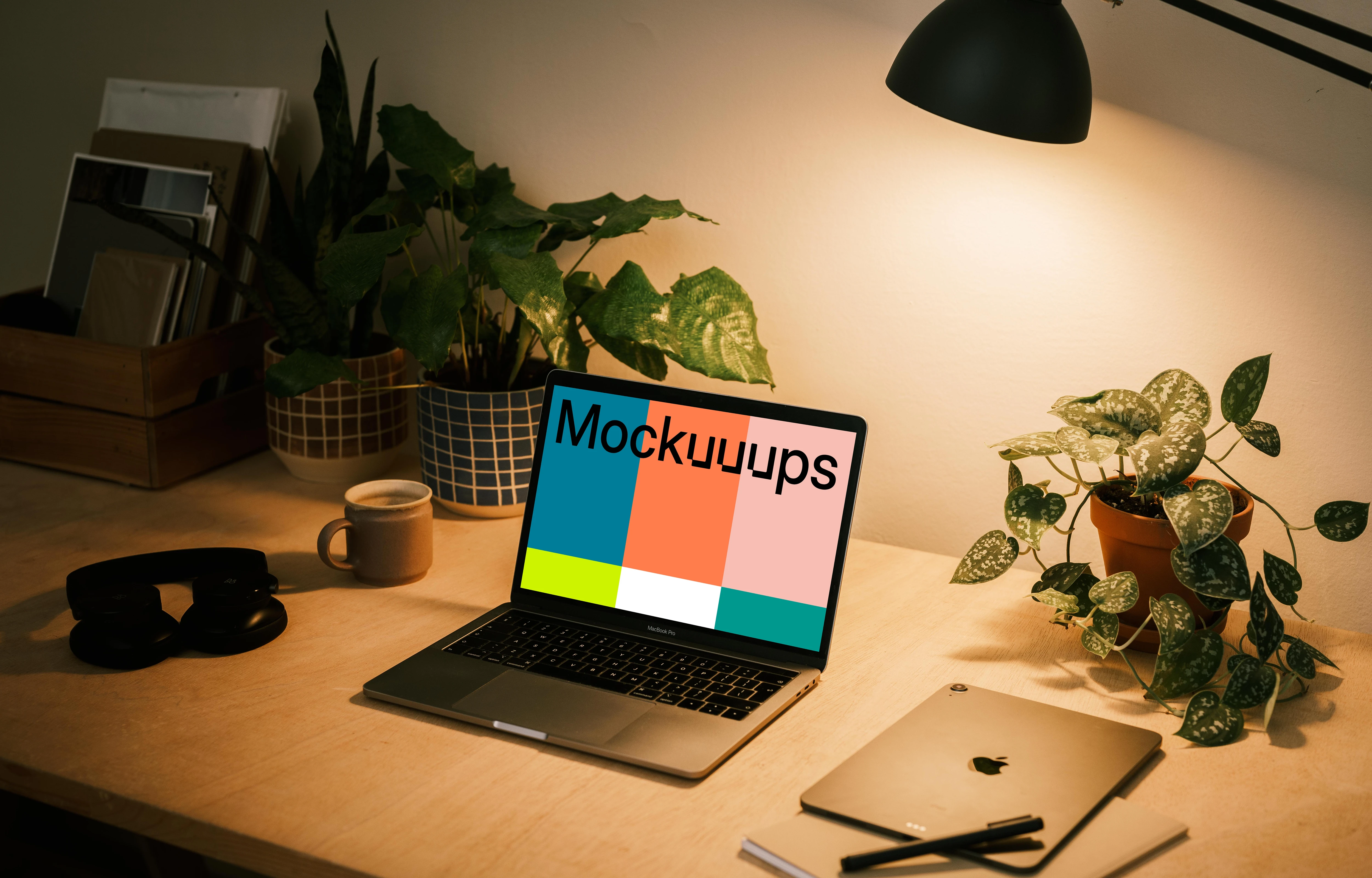 MacBook Pro mockup with a notepad and iPad Air at the side