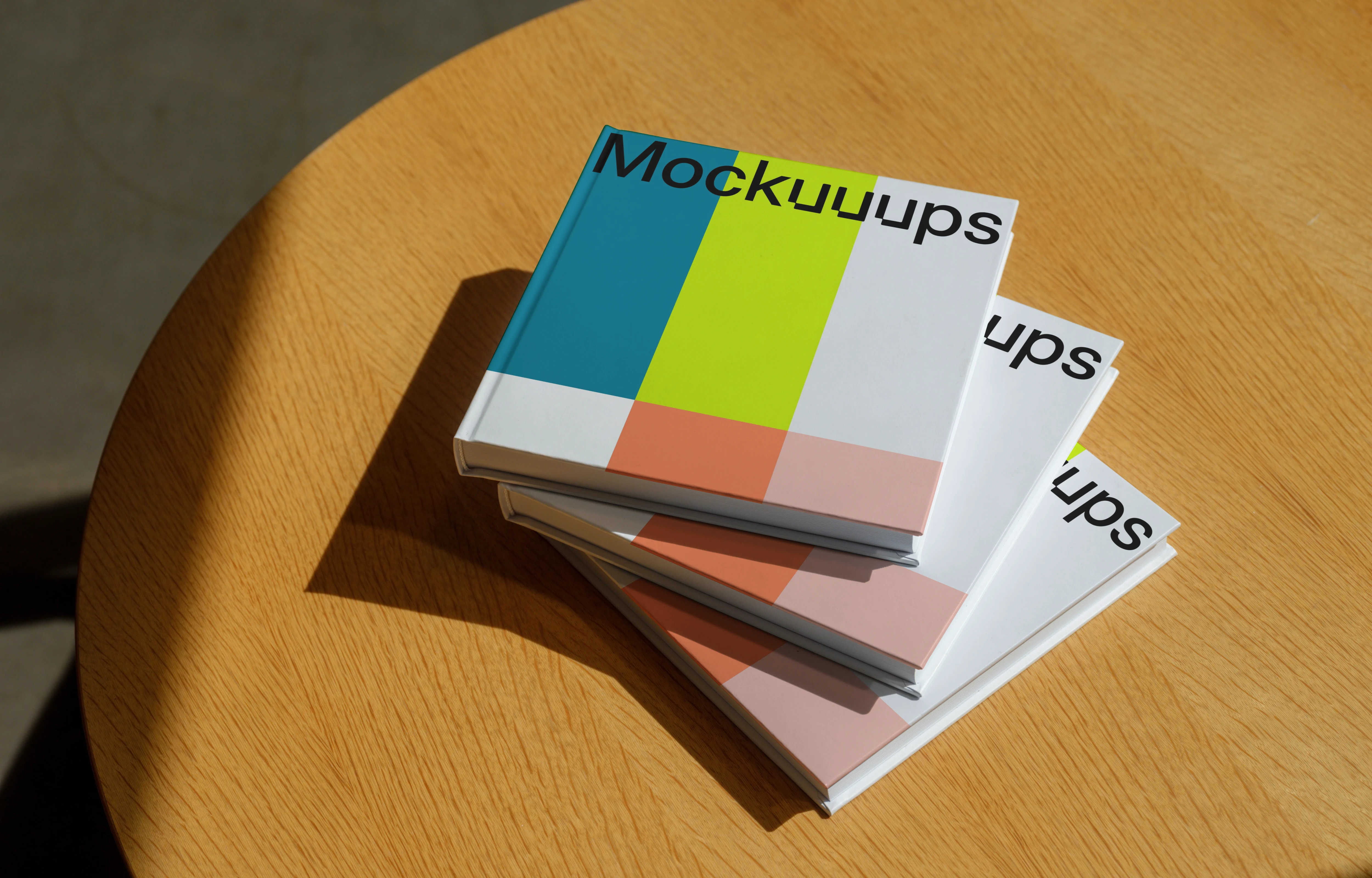 Mockup of stacked hardcover books on a wooden table
