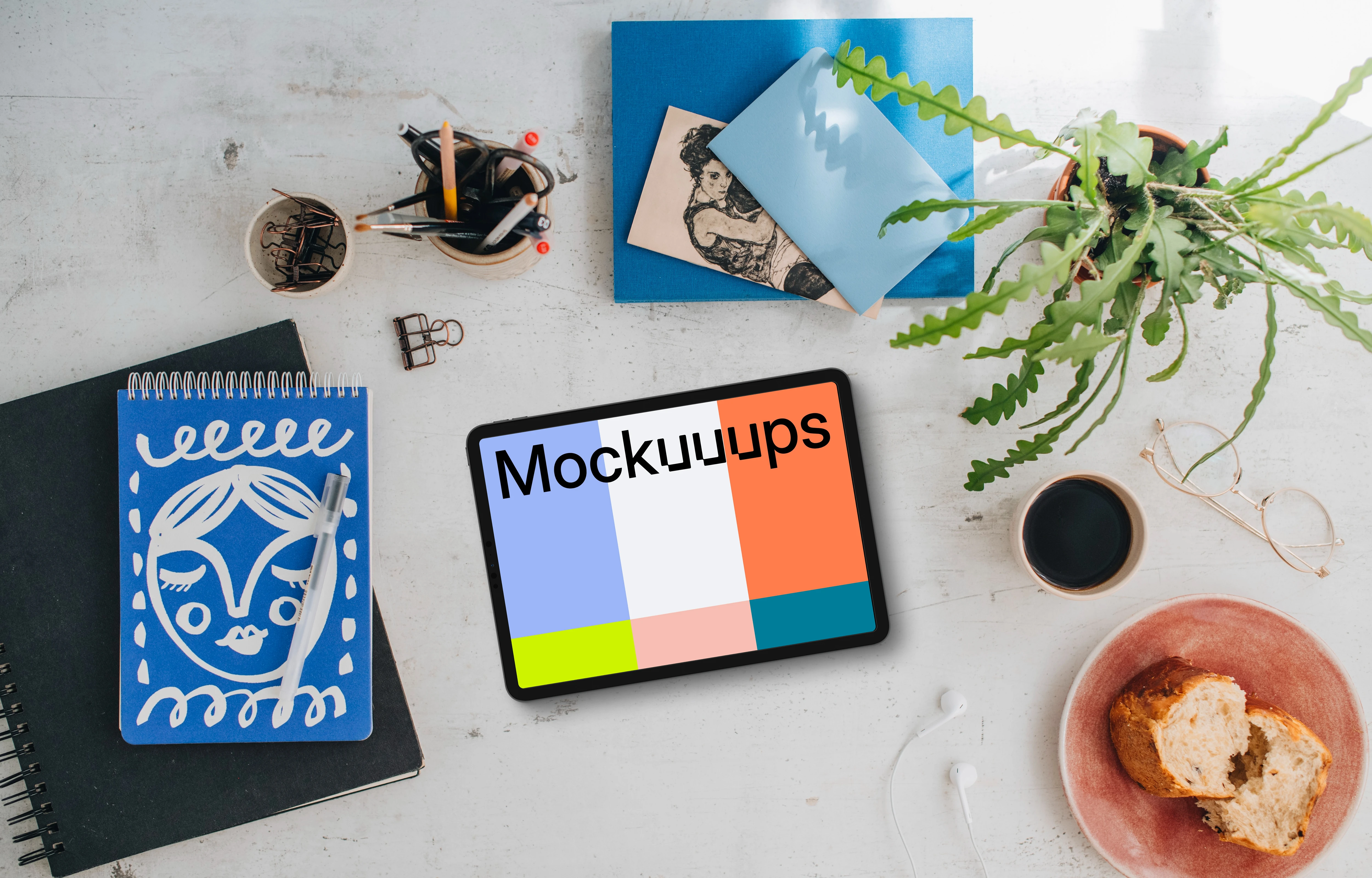 Mockup of tablet device with a plant and coffee on the side