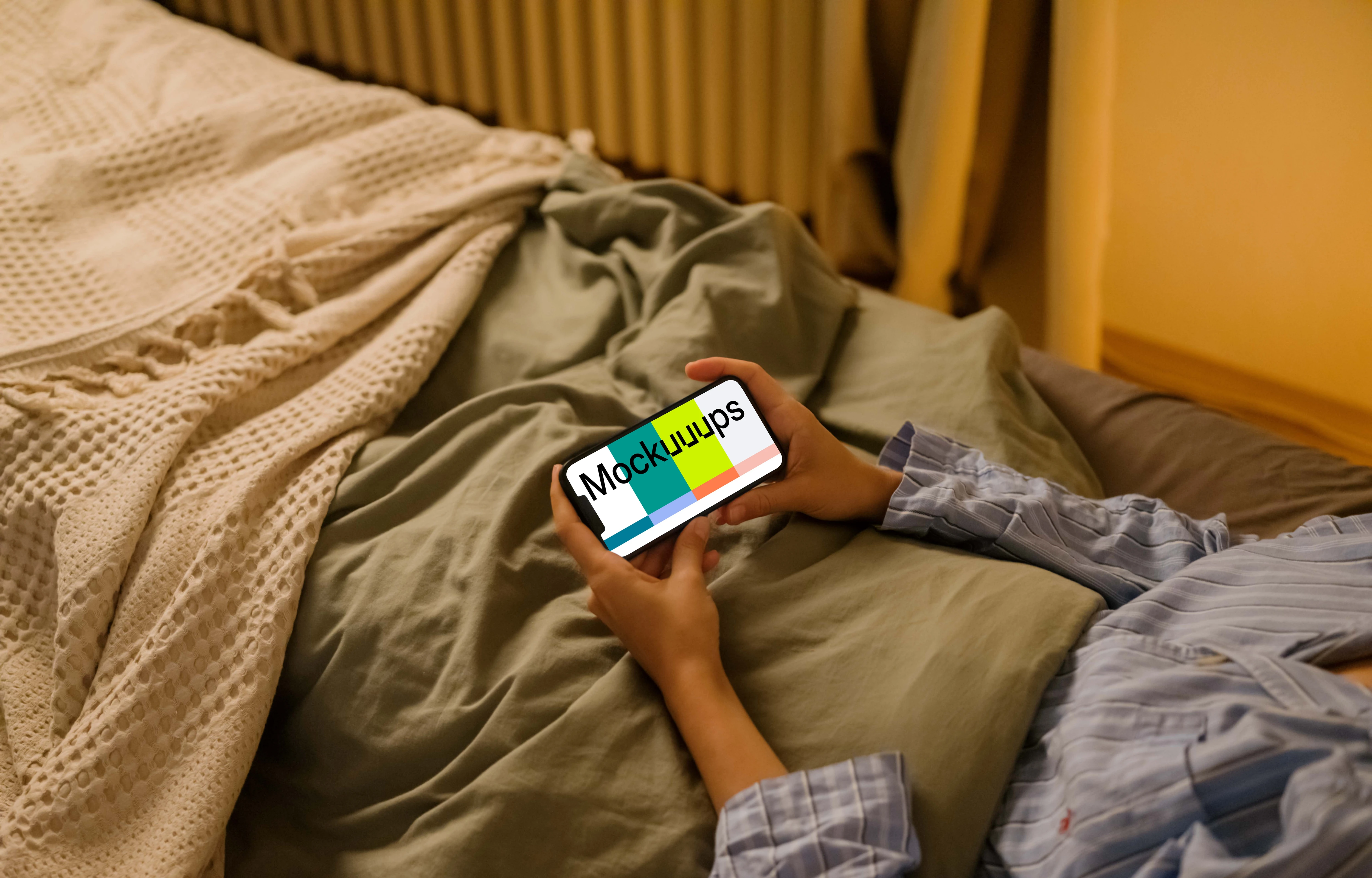 Woman in bed holding an iPhone mockup