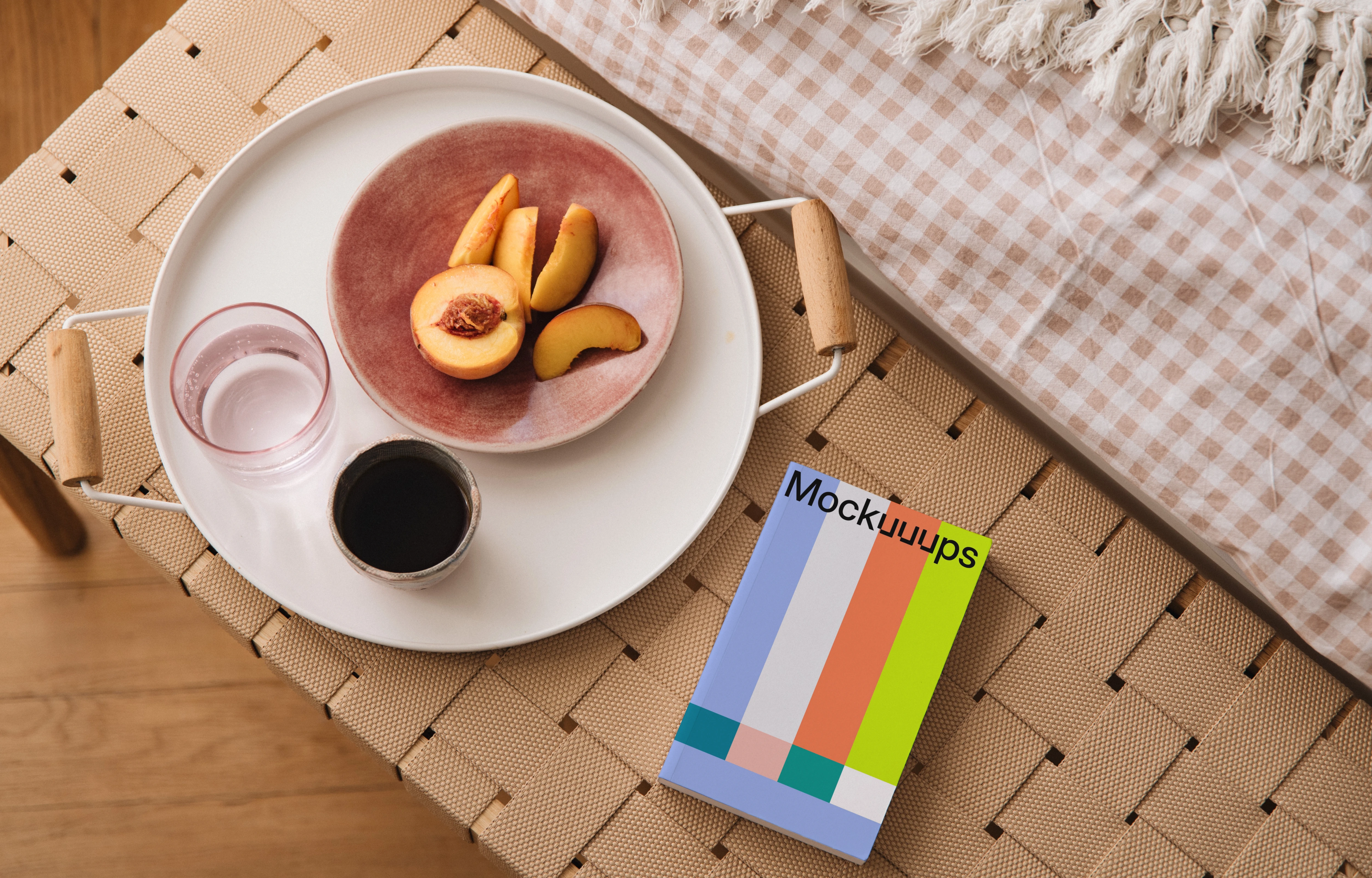 Paperback mockup on a woven bench with a breakfast tray