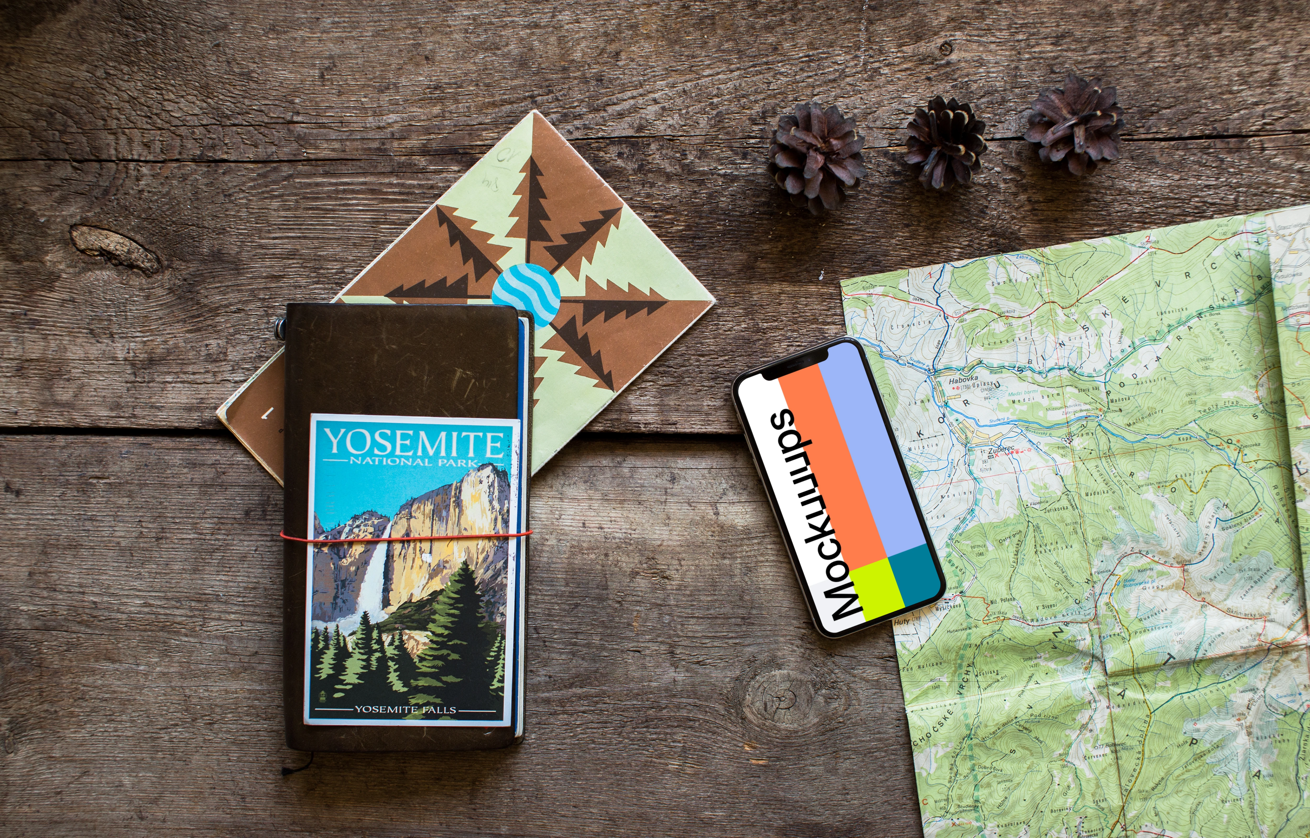 Rotated iPhone XS mockup with journal on the side