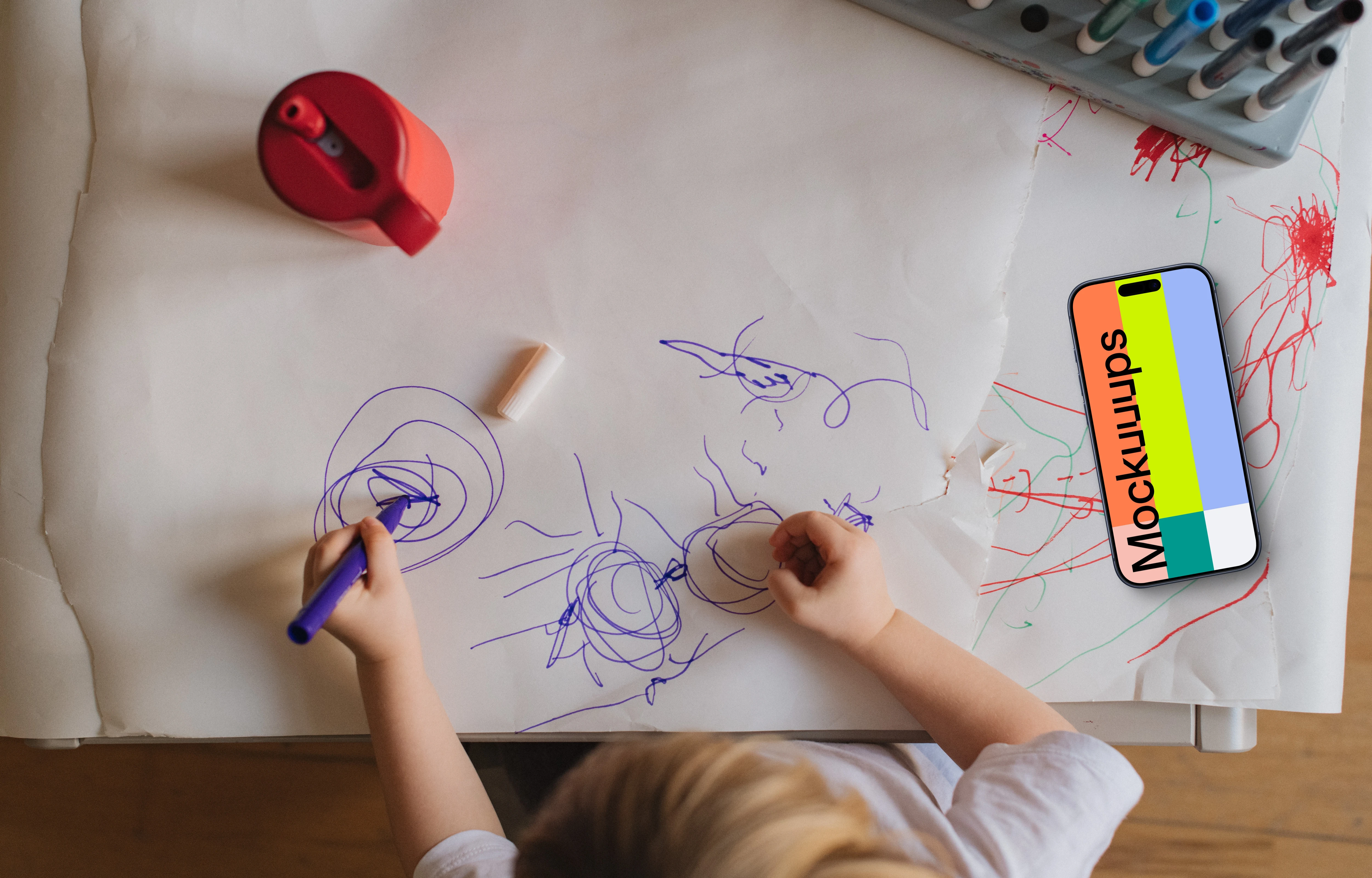 Smartphone mockup beside child's artwork