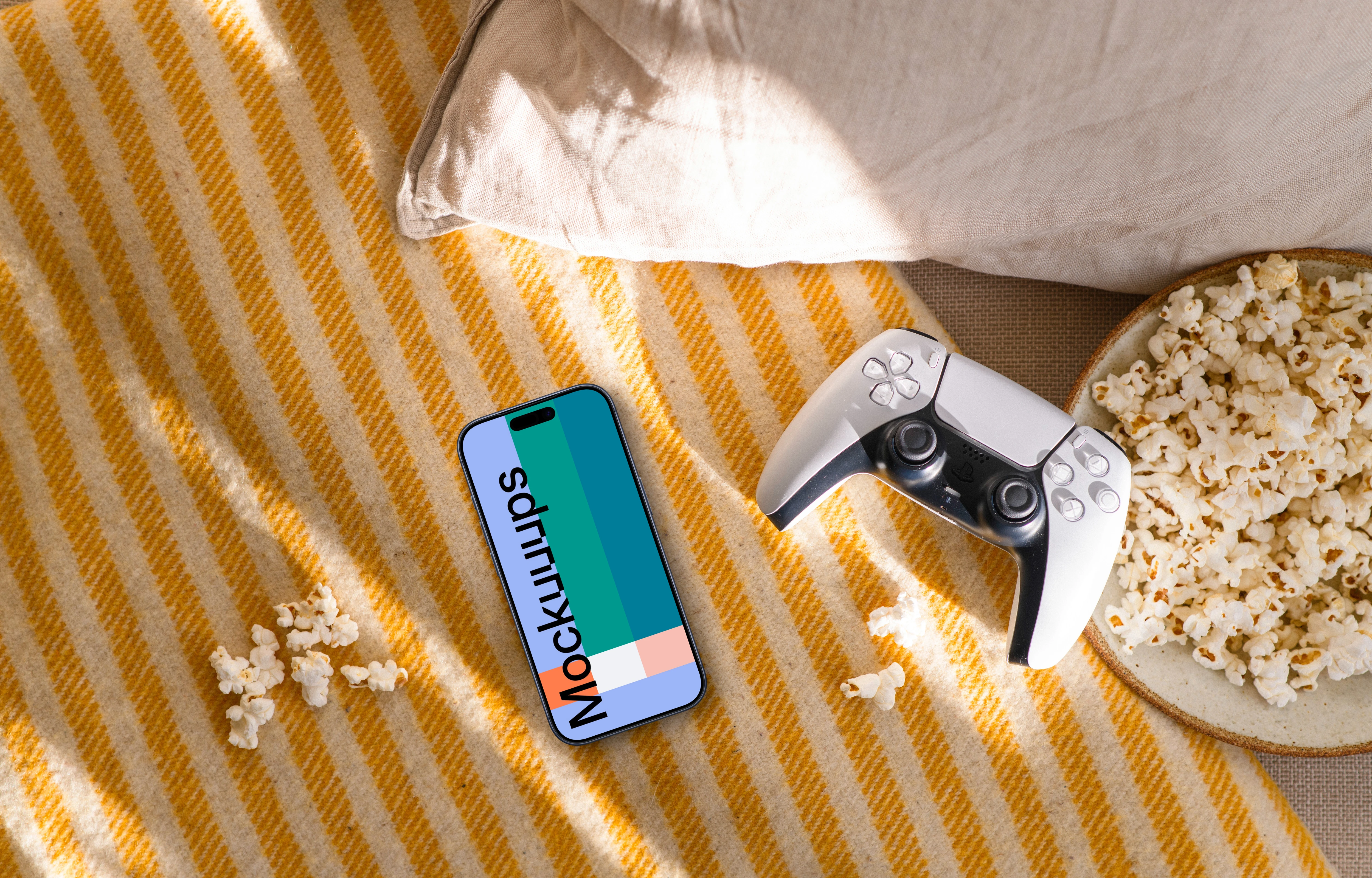 Smartphone mockup with gaming controller and snacks on cozy sofa