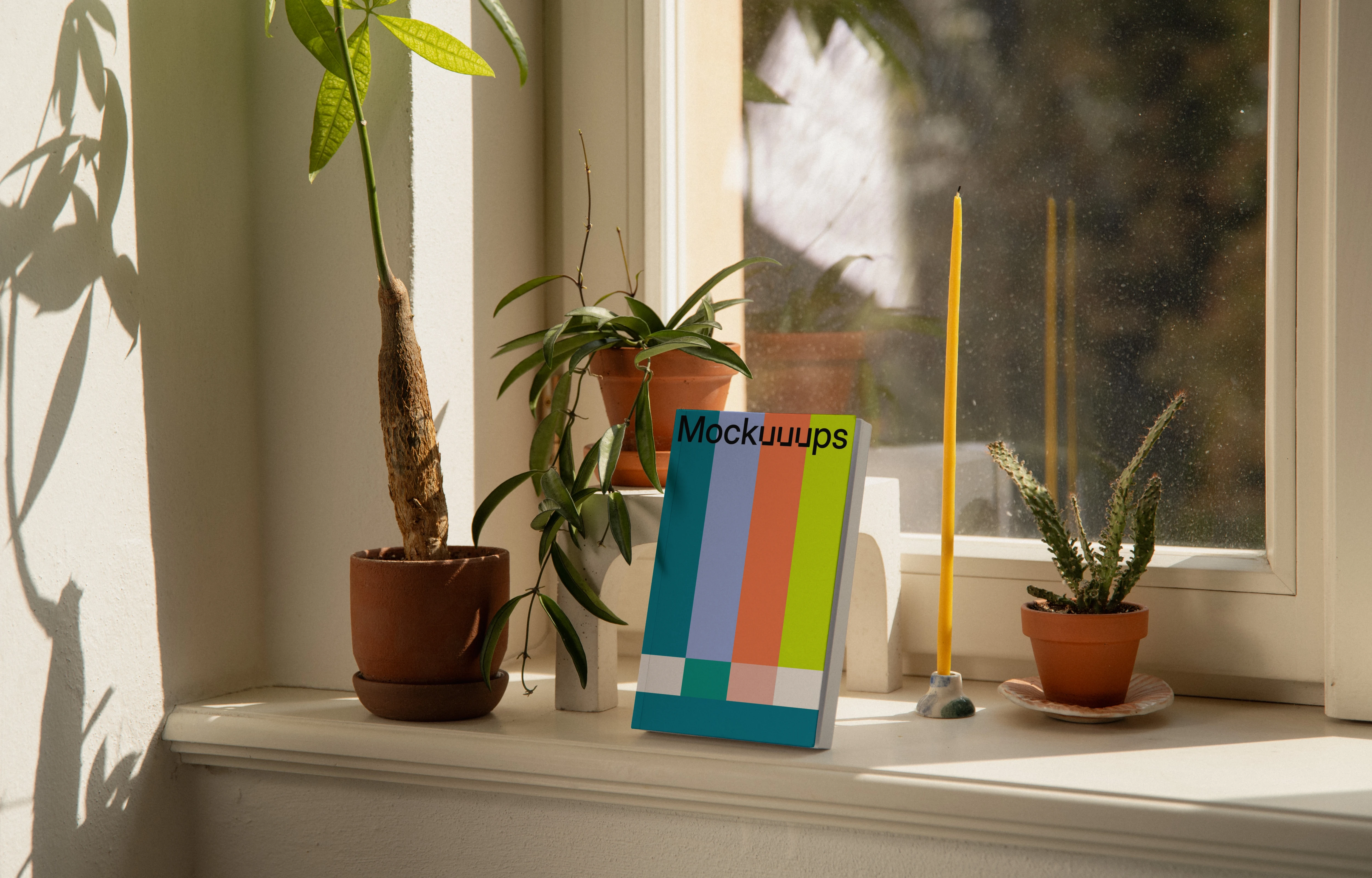 Softcover book mockup on a windowsill with plants