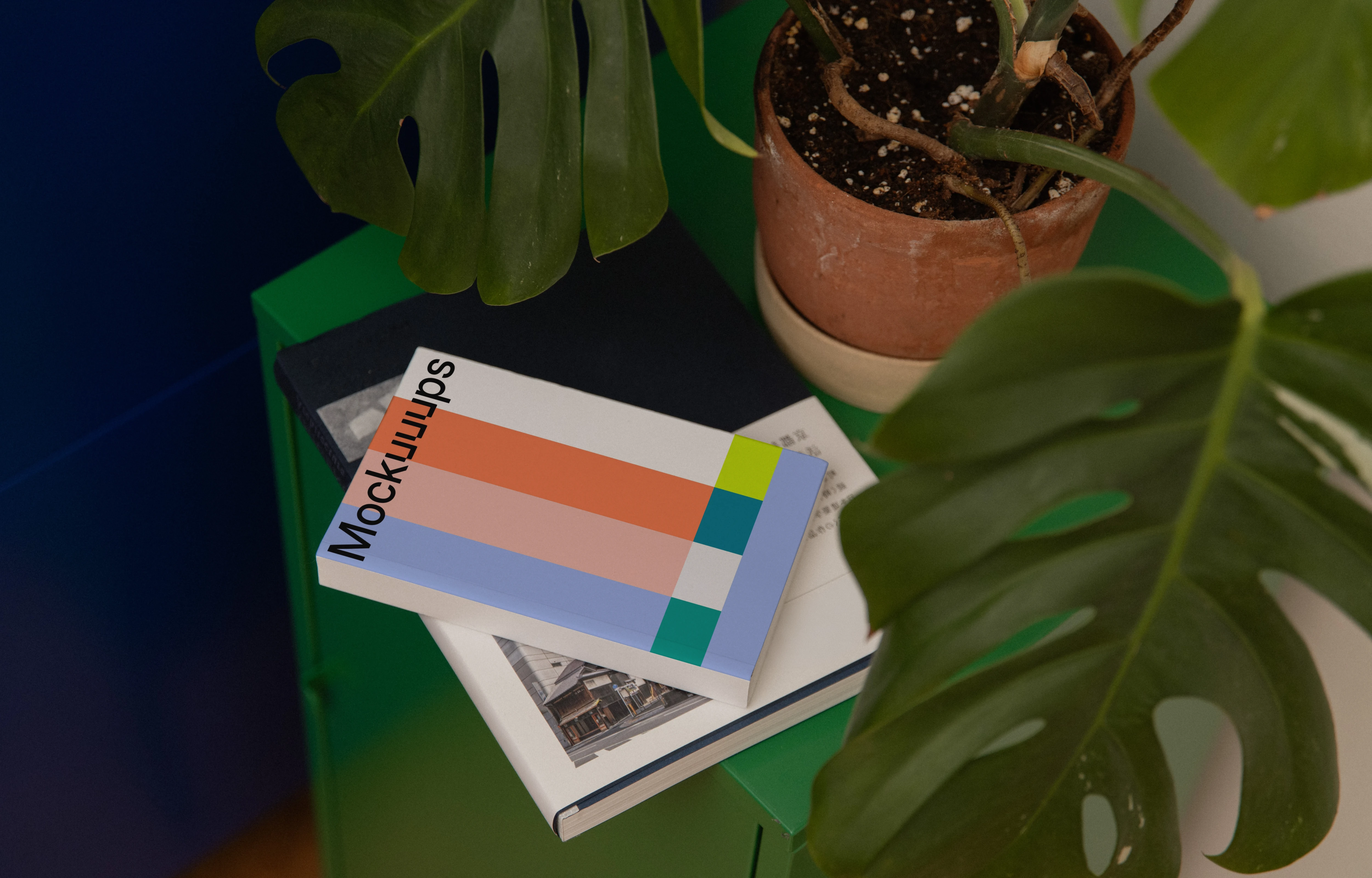 Softcover mockup on a green cabinet with plant