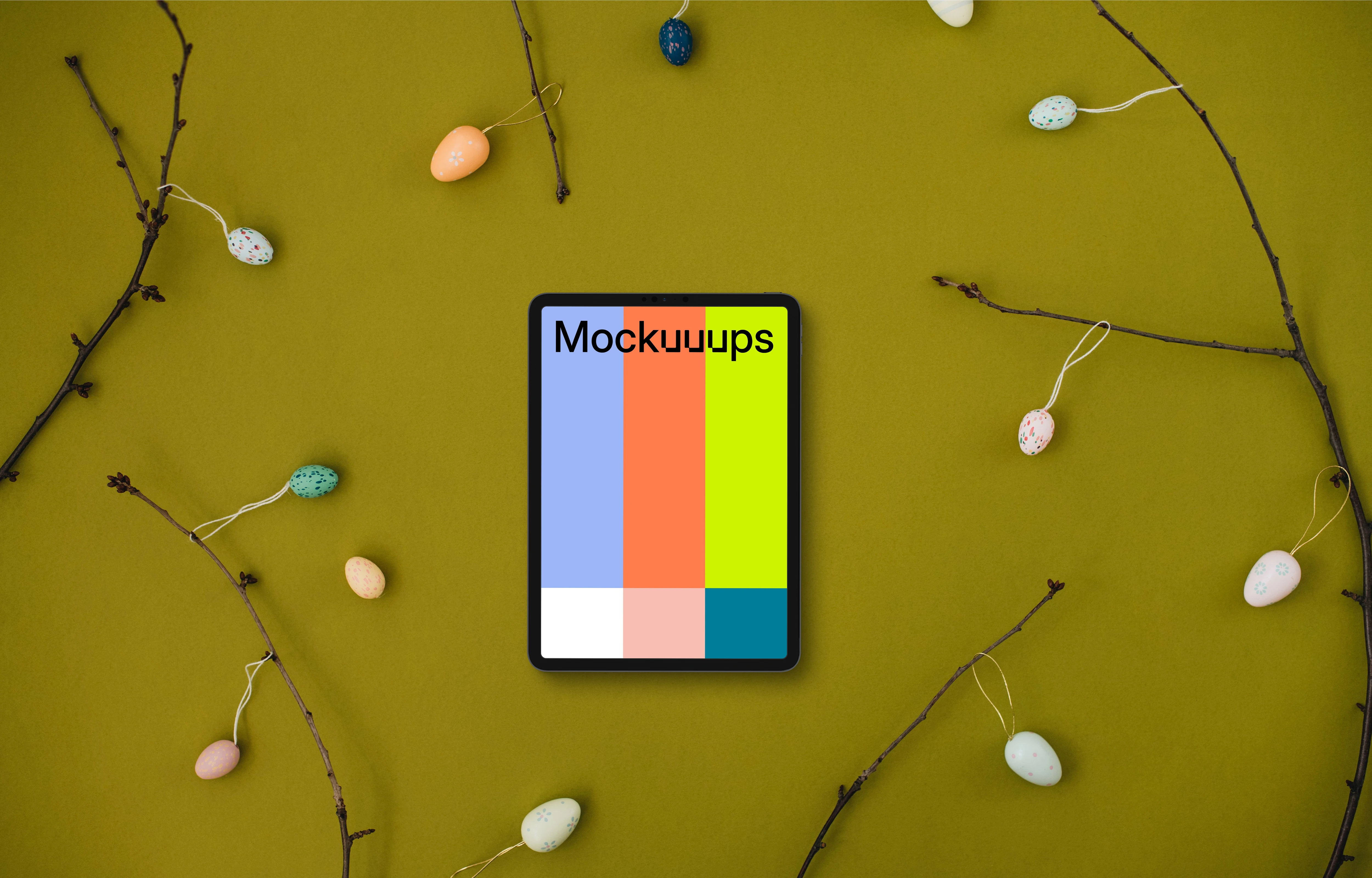 Tablet mockup among Easter eggs on branches
