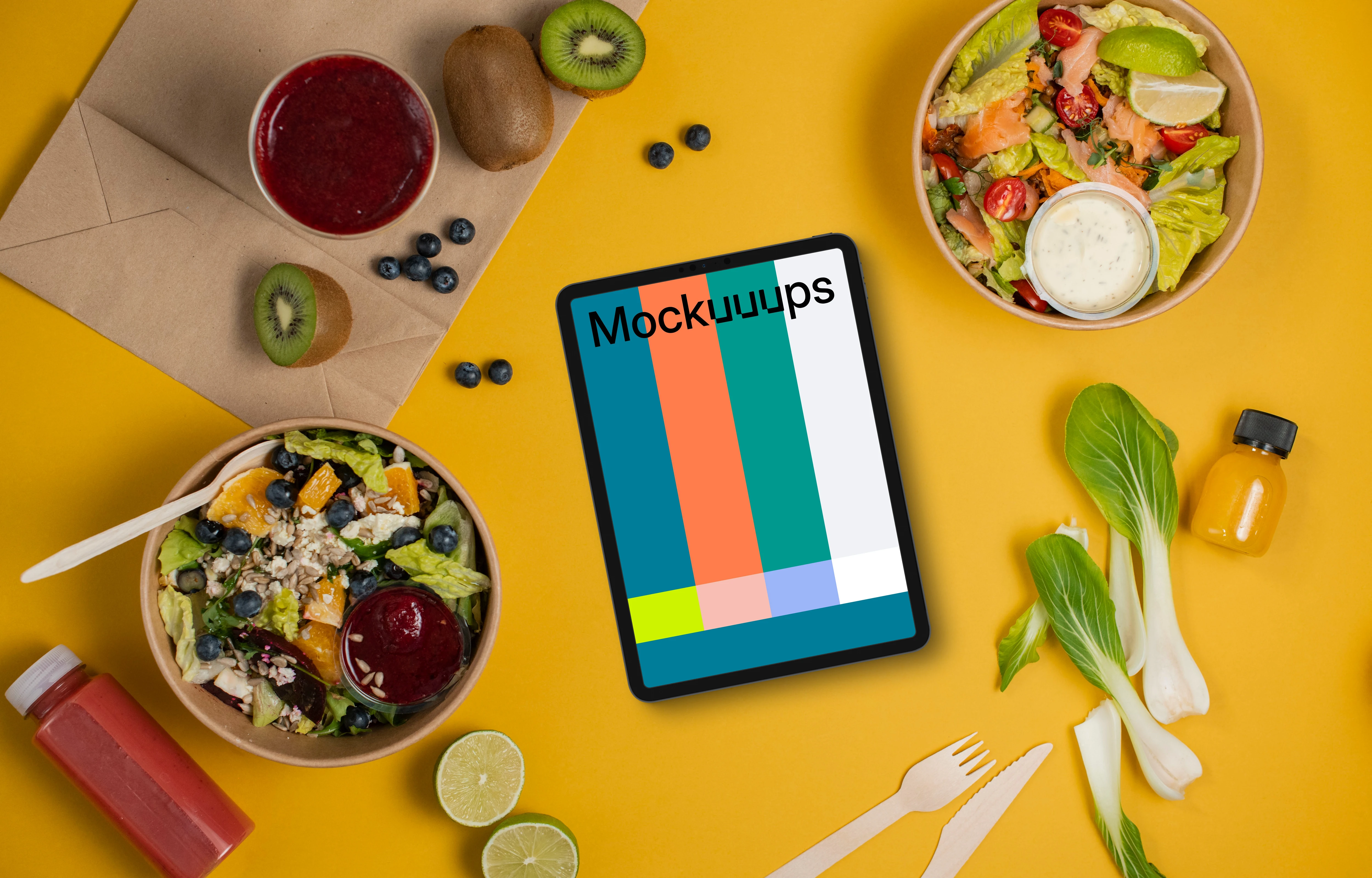 Tablet mockup surrounded by veggie salads and fruits
