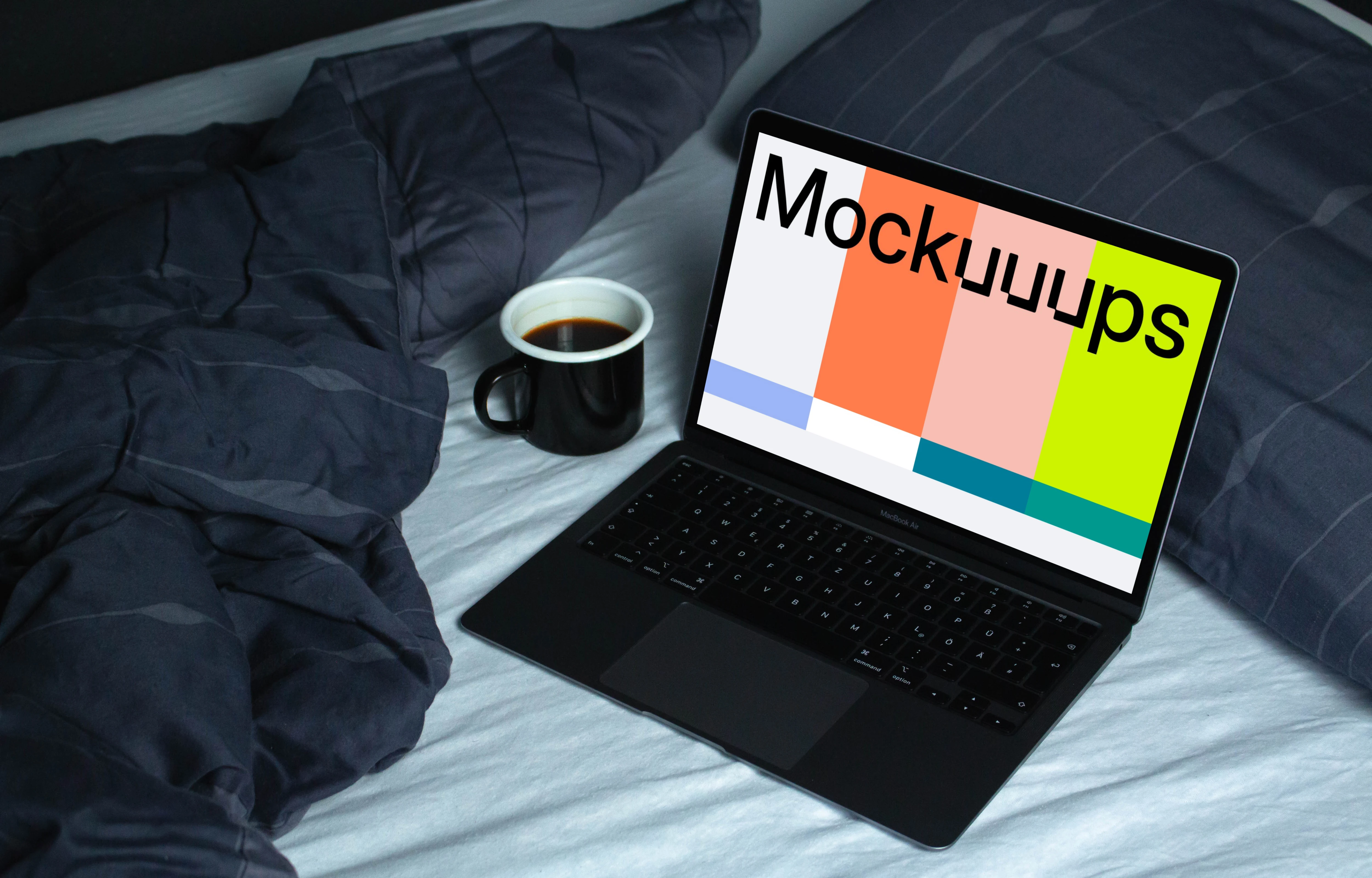 MacBook mockup on a white bed beside a cup of coffee and blue duvet 