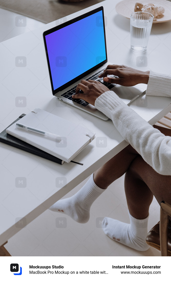 MacBook Pro Mockup on a white table with a notebook and cup of water