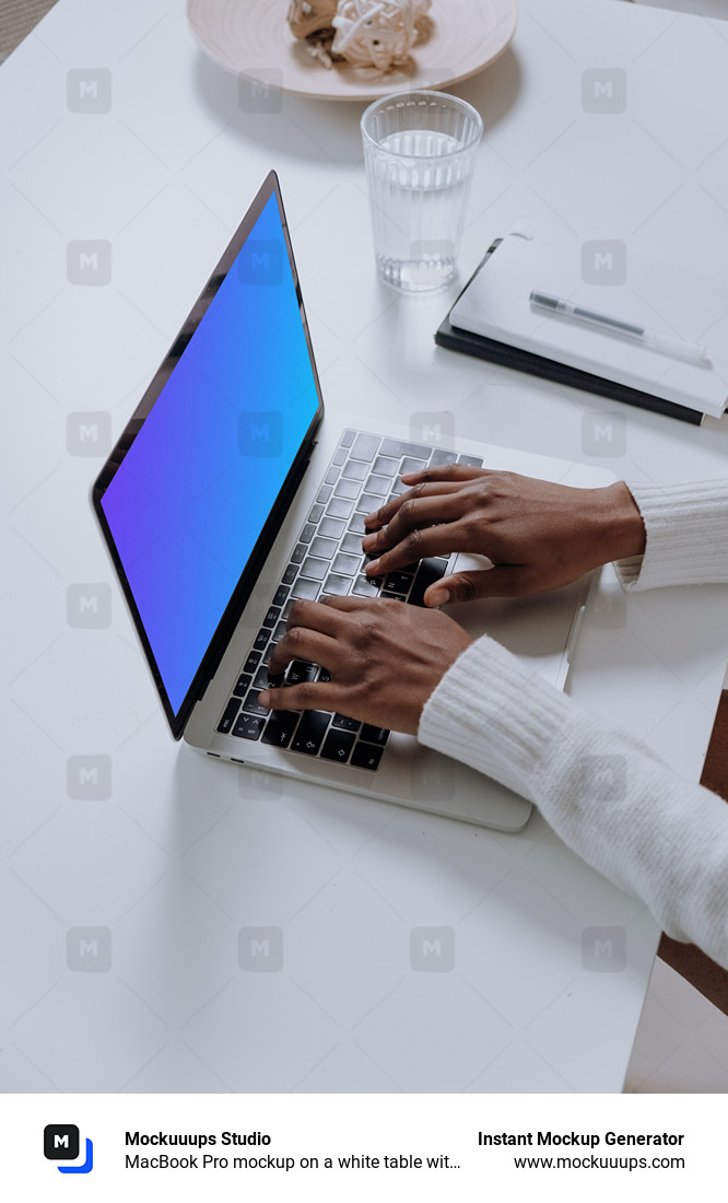 MacBook Pro mockup on a white table with glass of water at the side