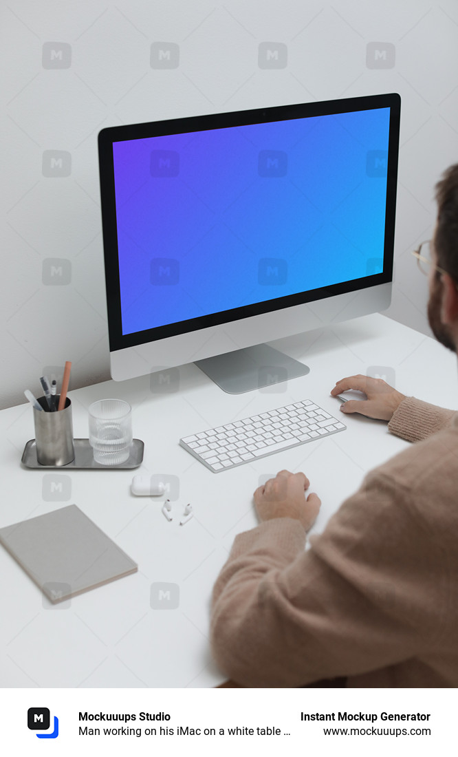 Man working on his iMac on a white table mockup