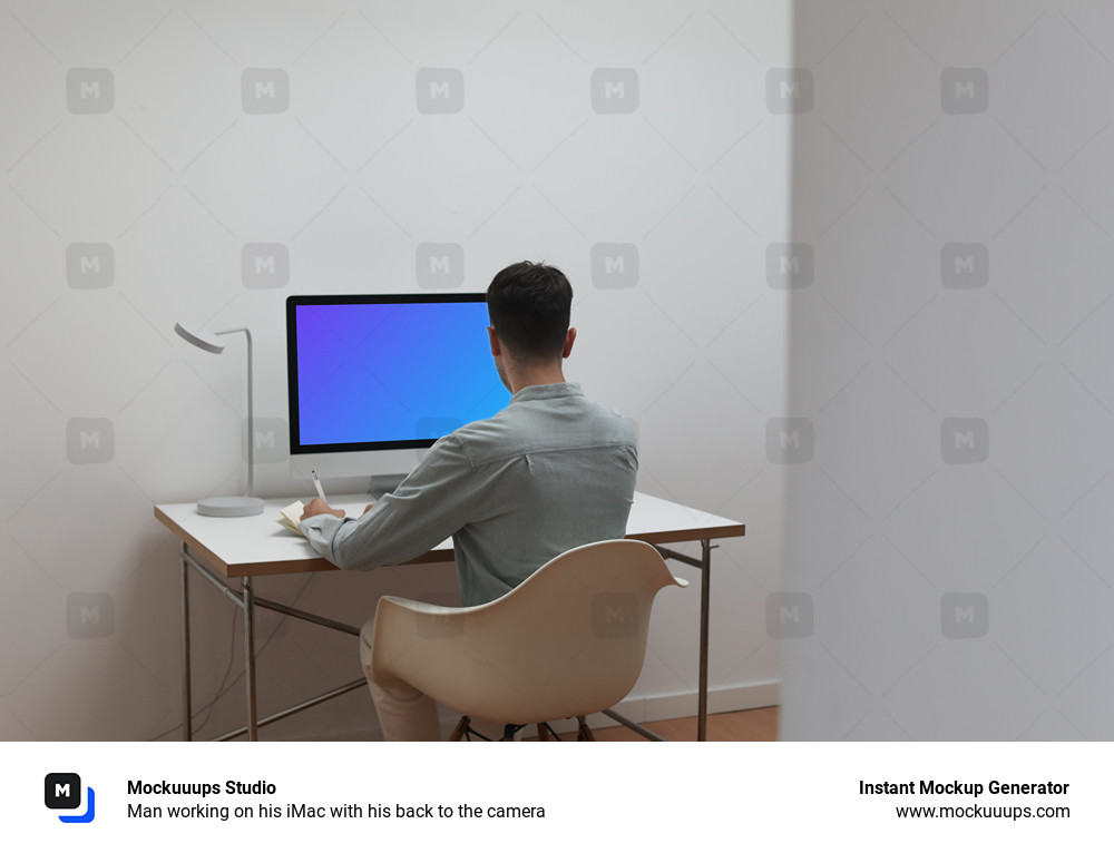 Man working on his iMac with his back to the camera