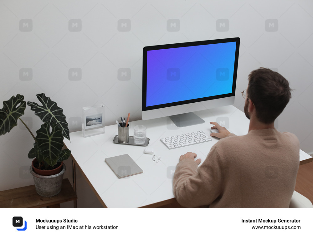 User using an iMac at his workstation