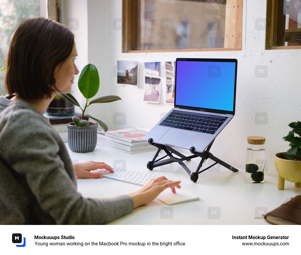 Young woman working on the Macbook Pro mockup in the bright office