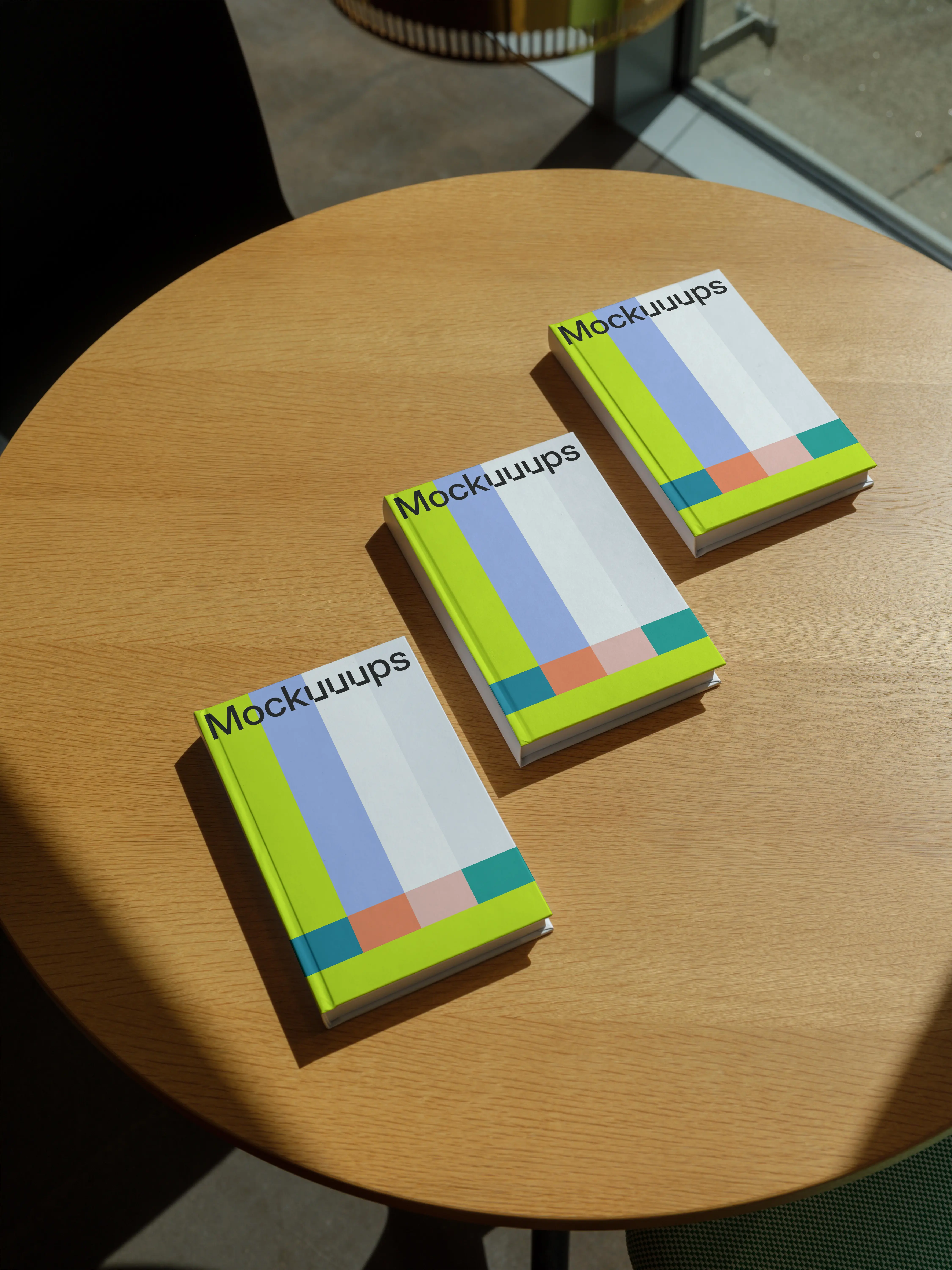 B-format book mockup on a round wooden table in natural light