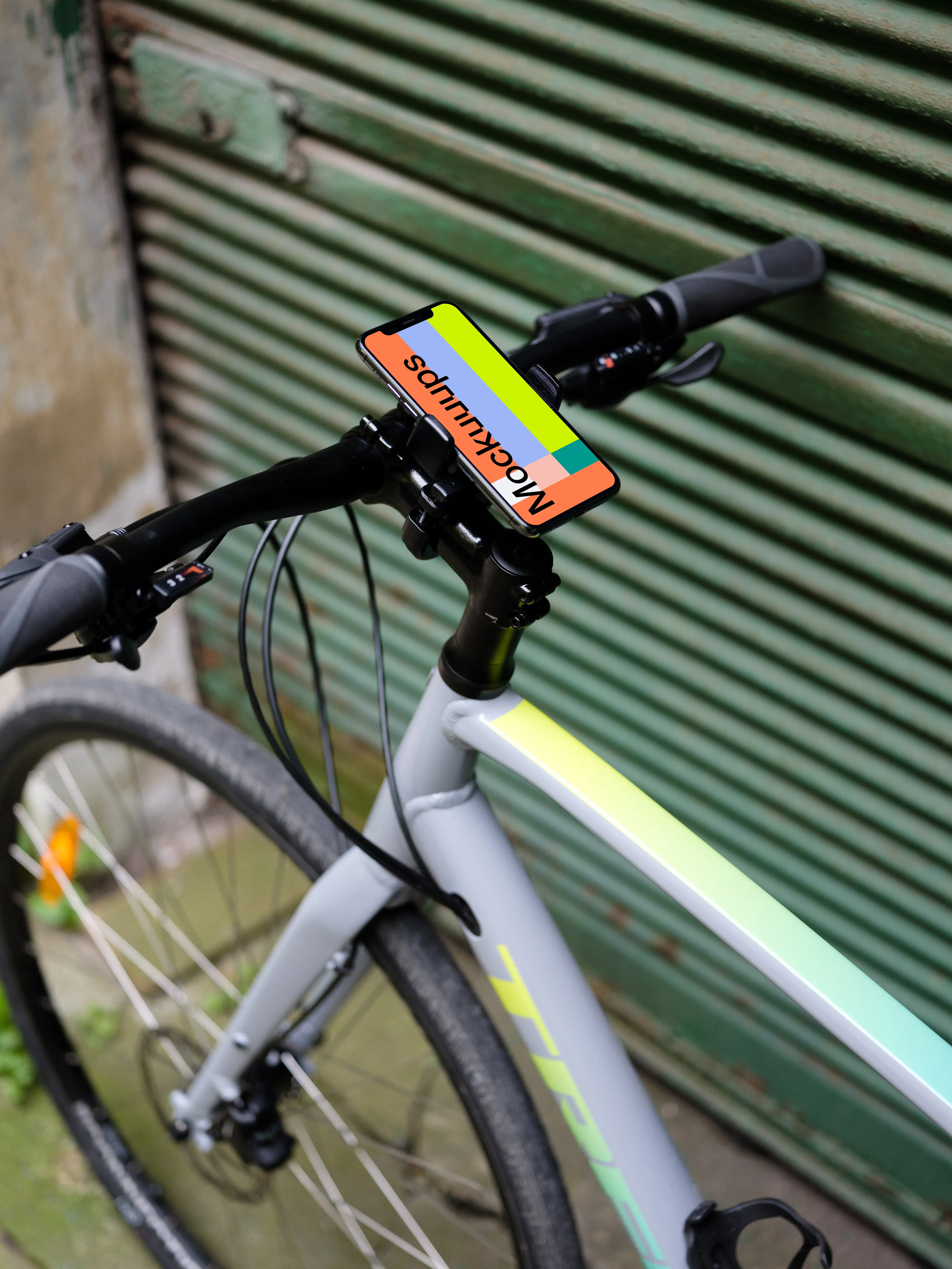 Bike leaned against a garage with iPhone 11 Pro mockup in bike mount