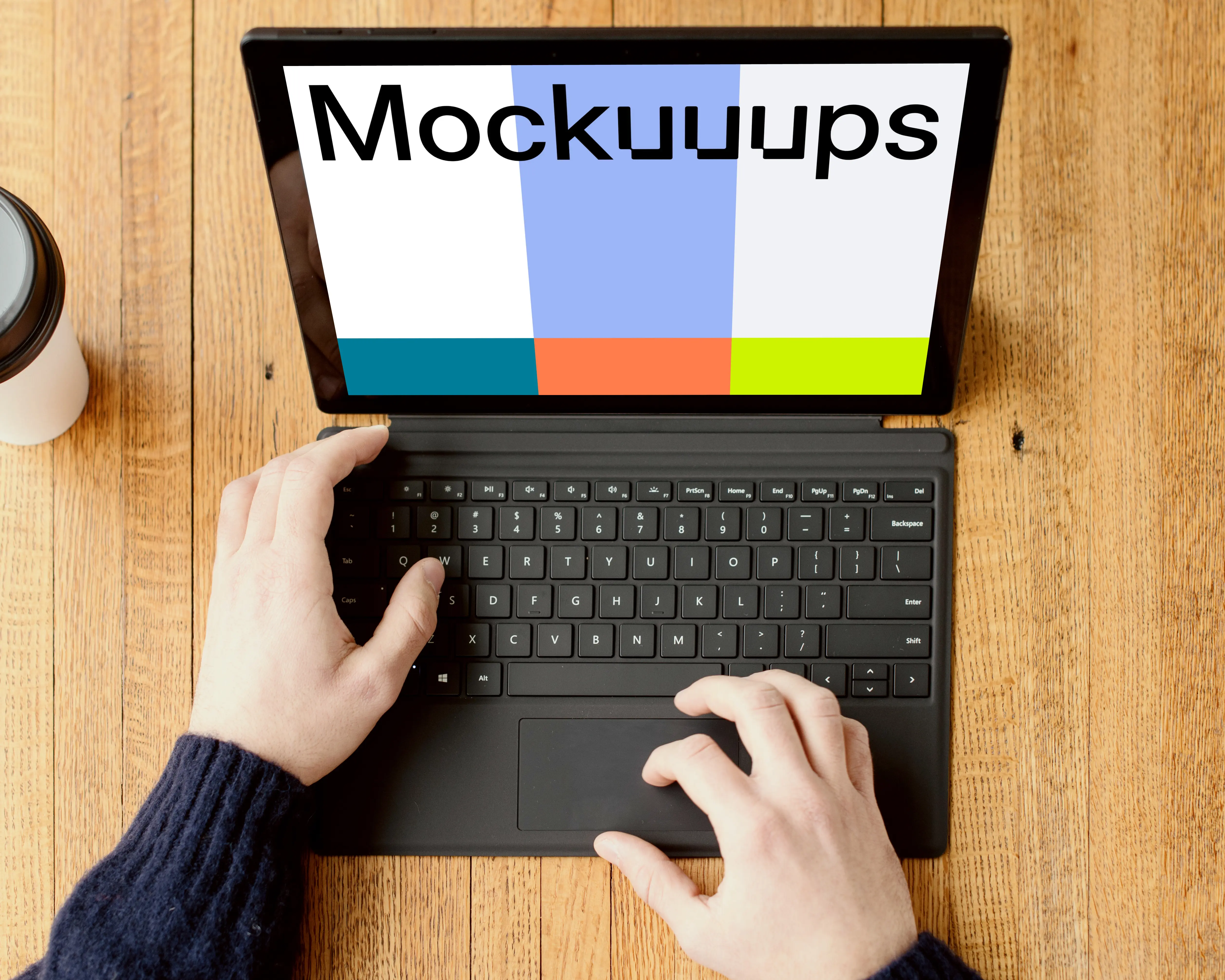 Black Microsoft Surface Laptop mockup on a wooden table.