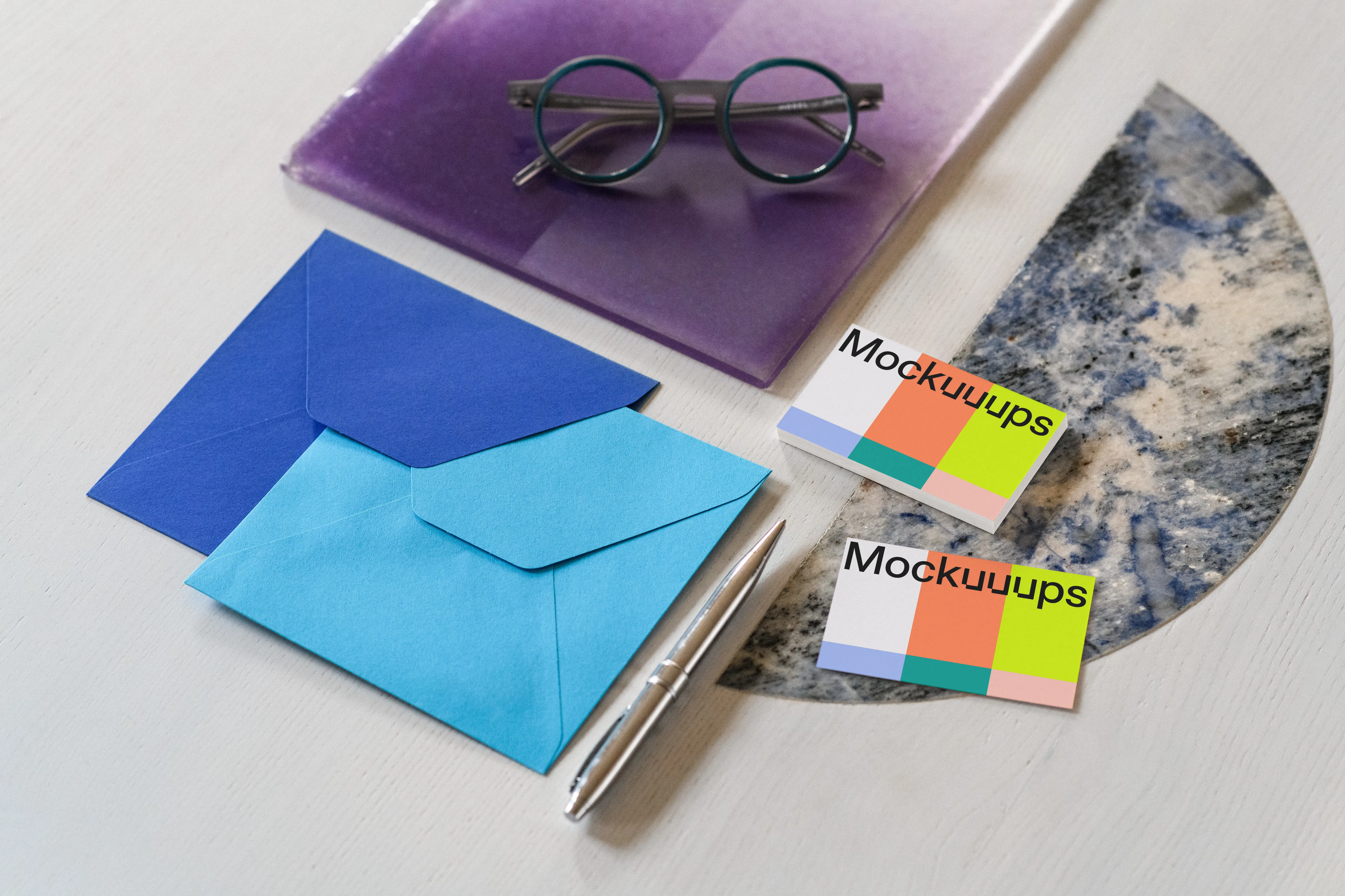 Business card mockup with colorful envelopes on a styled surface