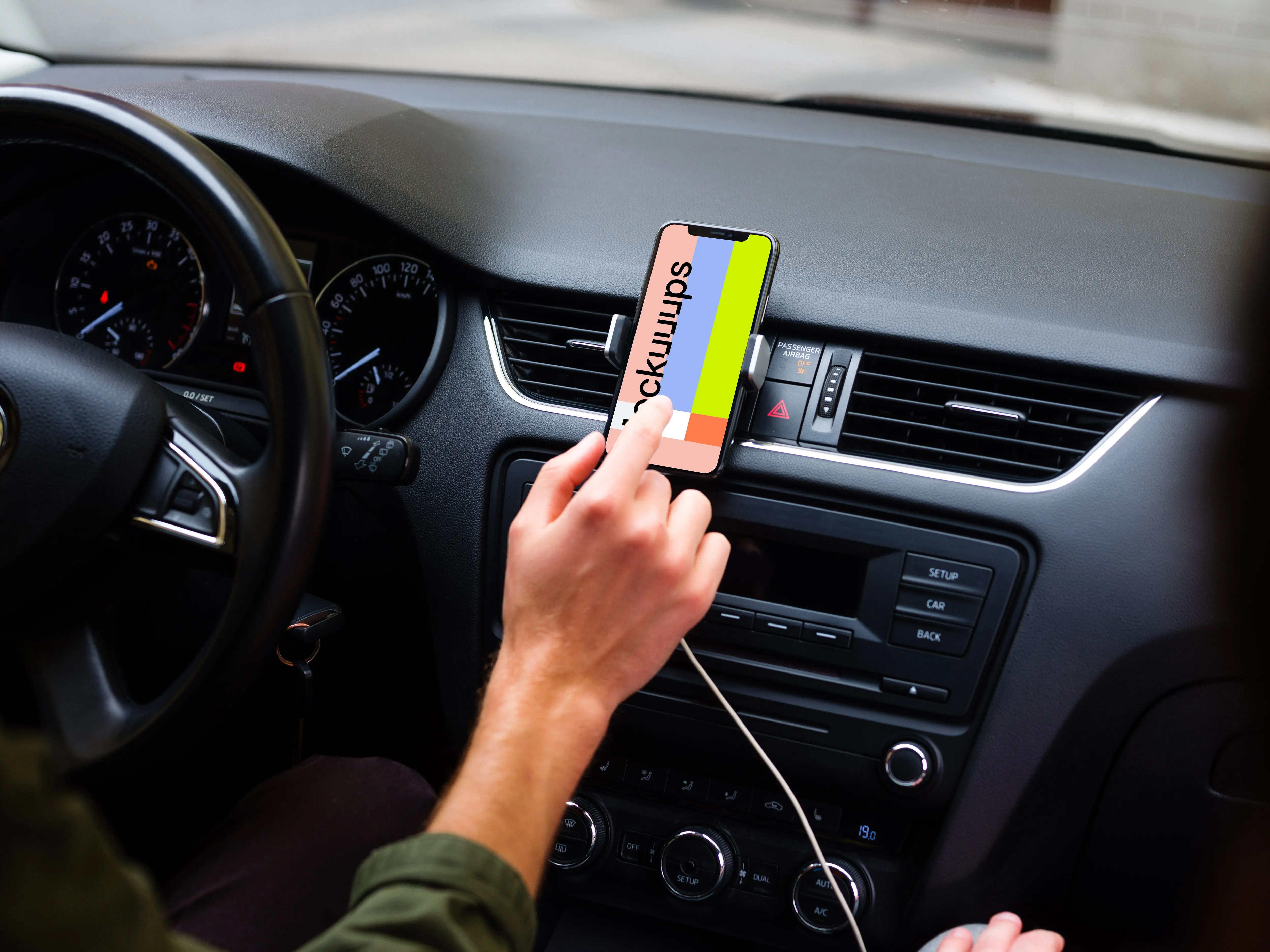 Driver interacting with iPhone 11 mockup in car mount