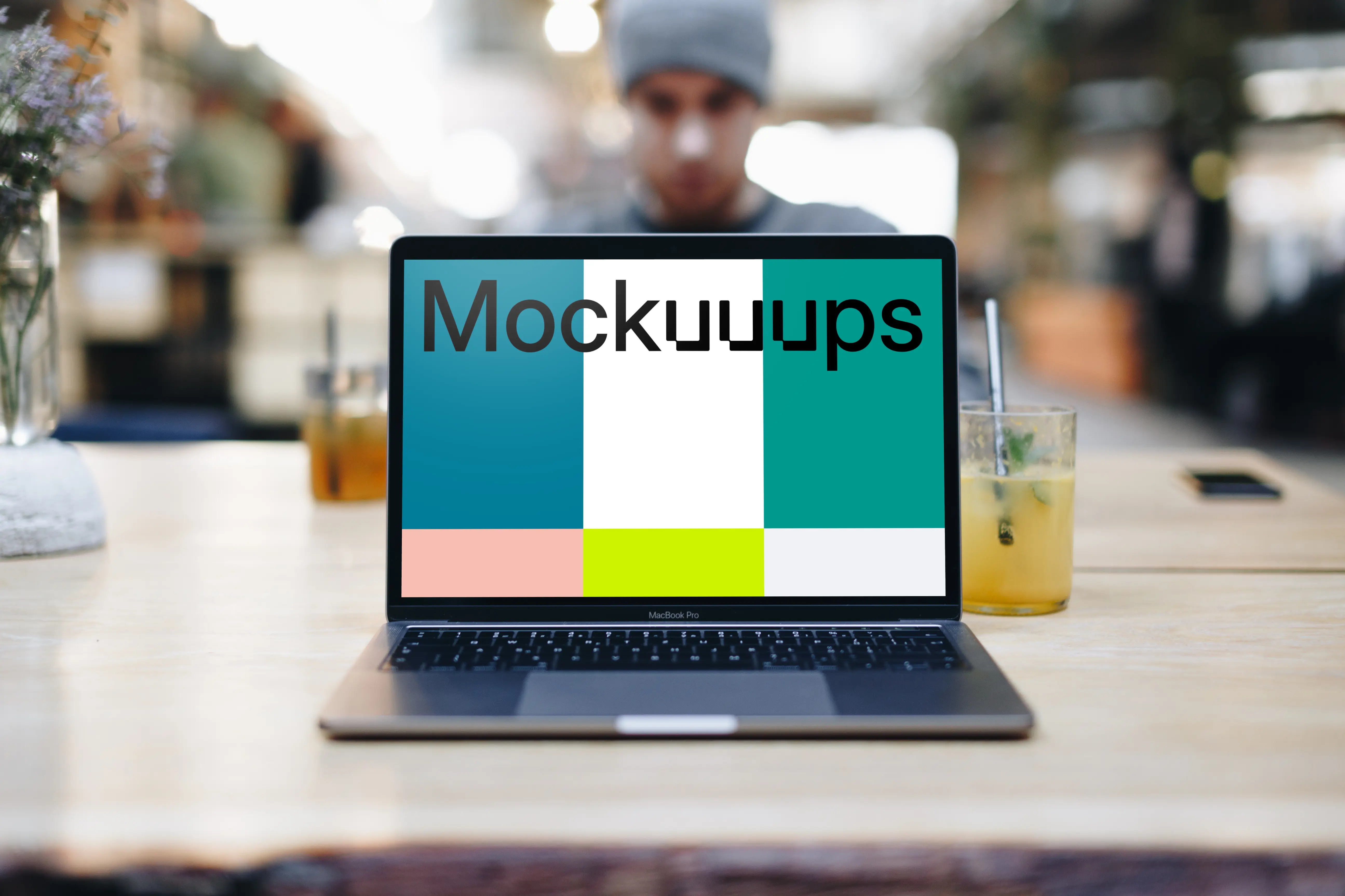 Front view of Macbook Pro mockup with co-worker behind