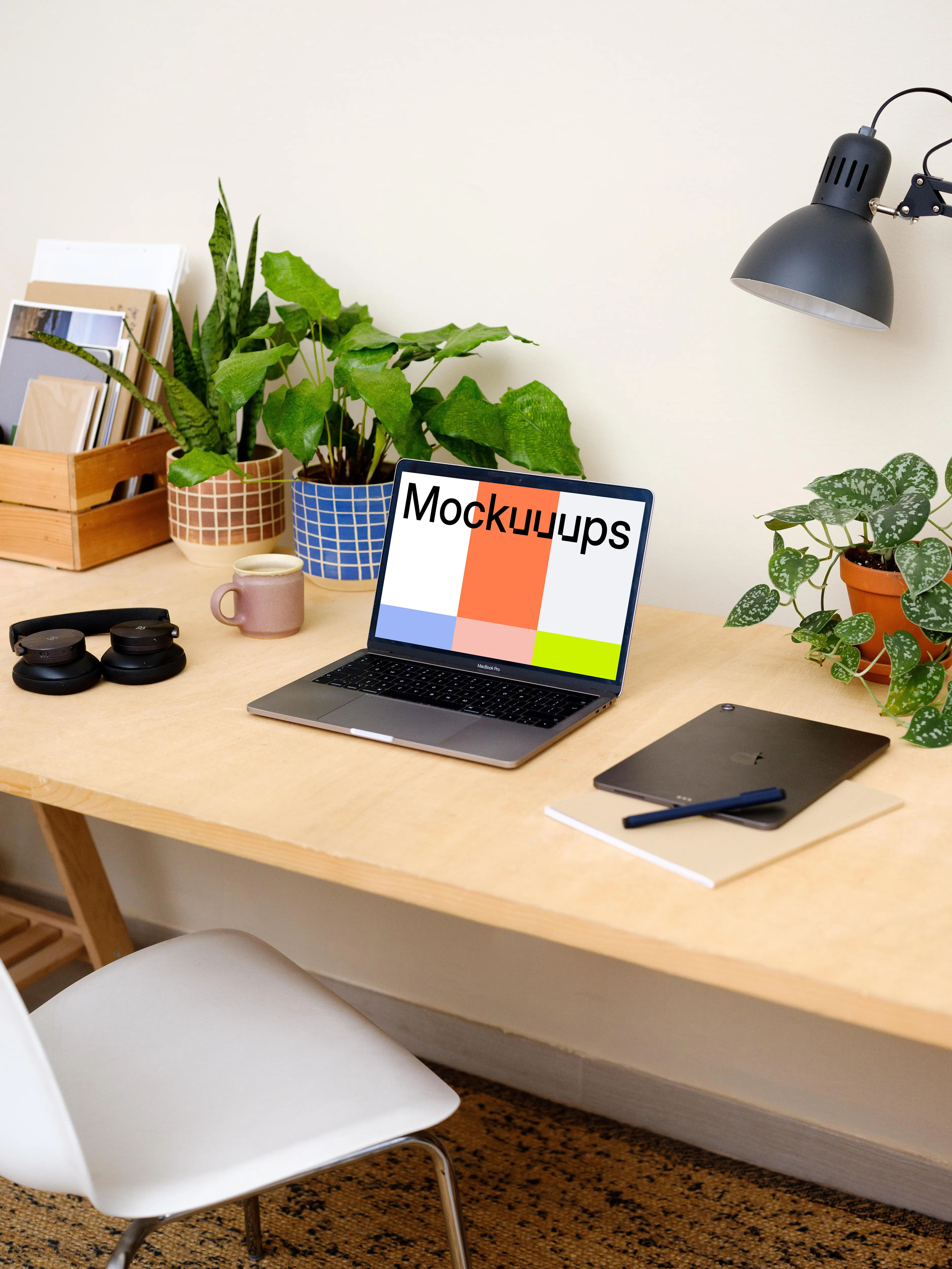 Grey MacBook Pro on a table with plants in the background