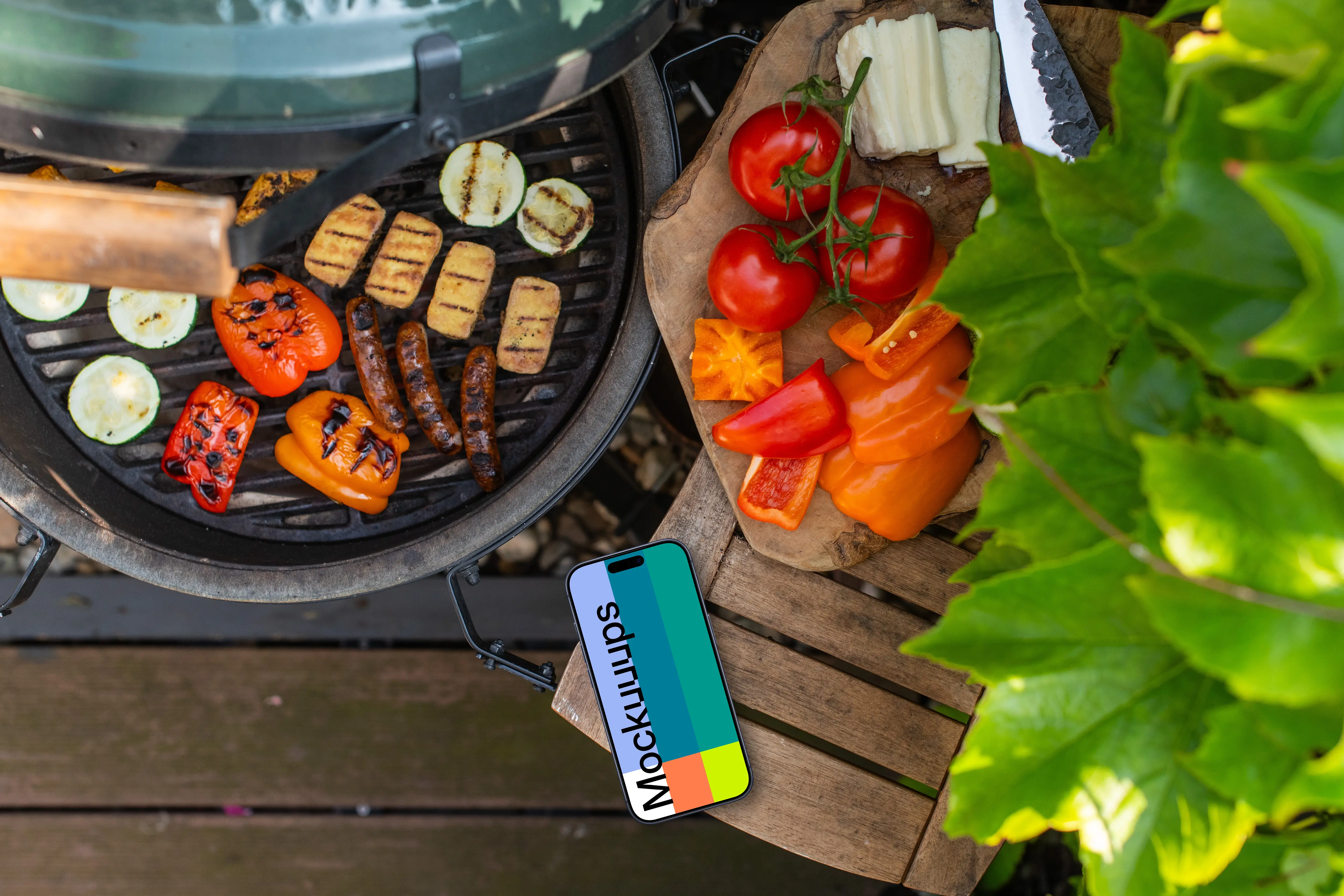 Grilled vegetables next to the iPhone mockup