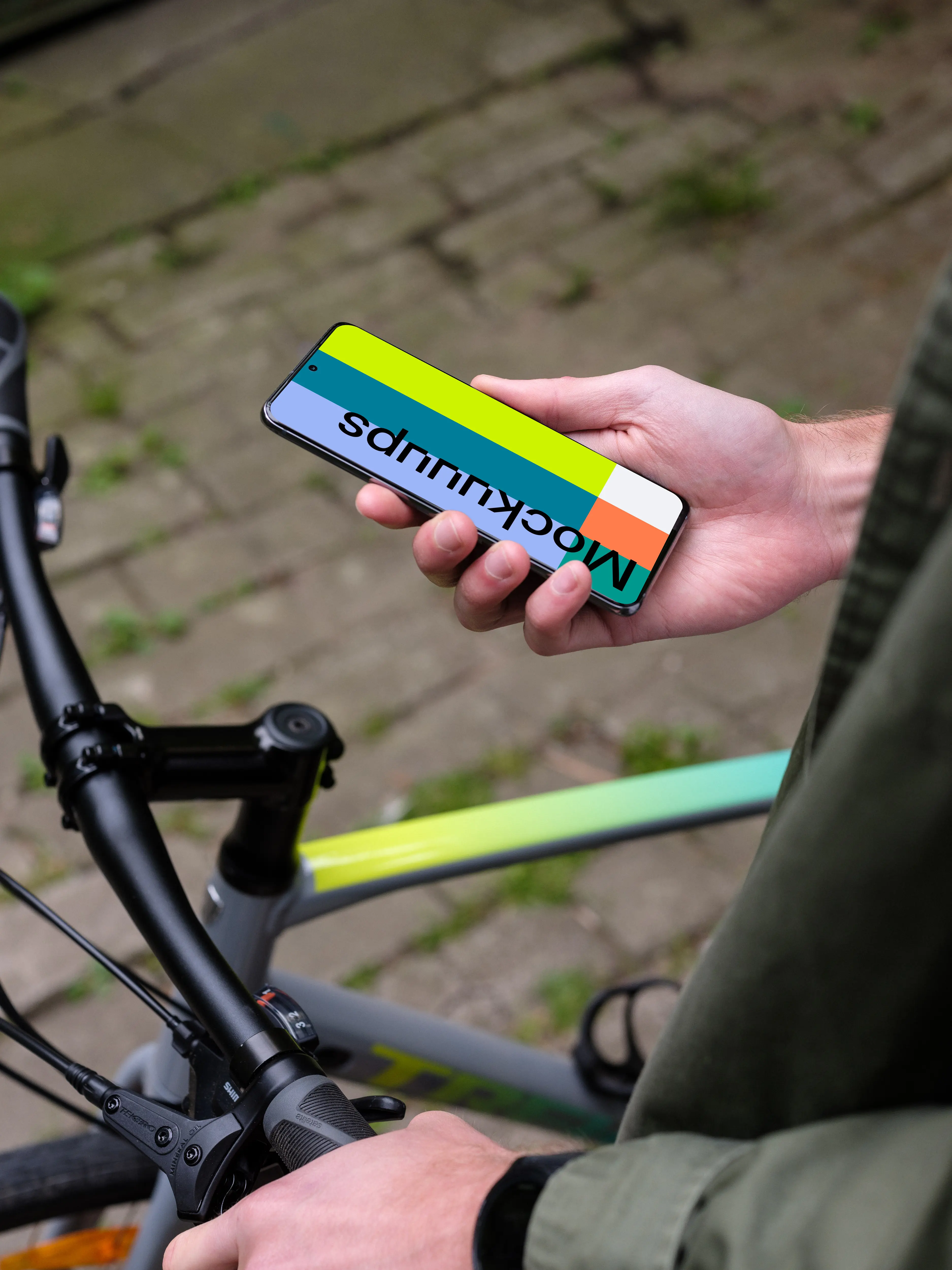 Holding Samsung S20 mockup in one hand next to a bike
