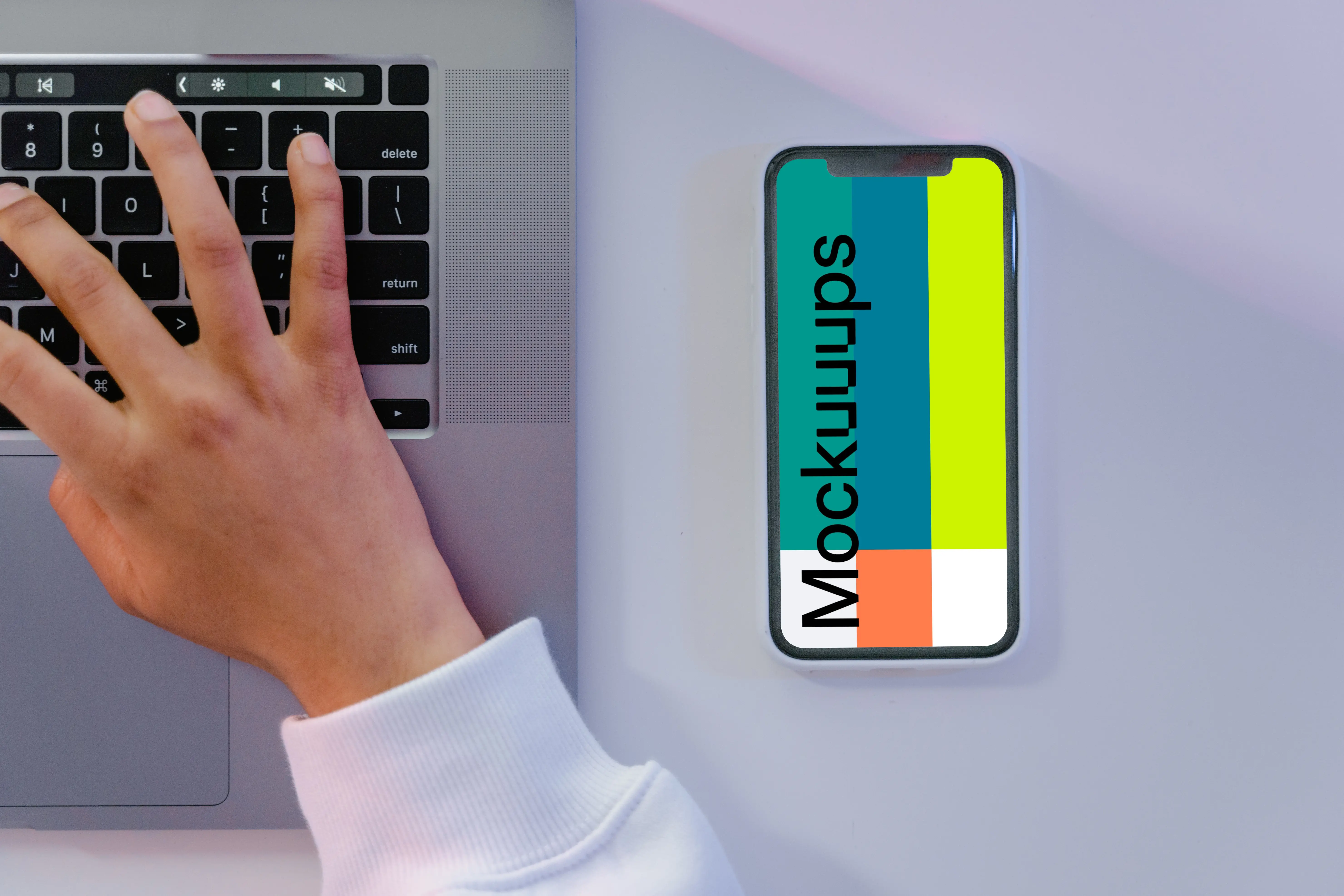 iPhone mockup beside grey MacBook