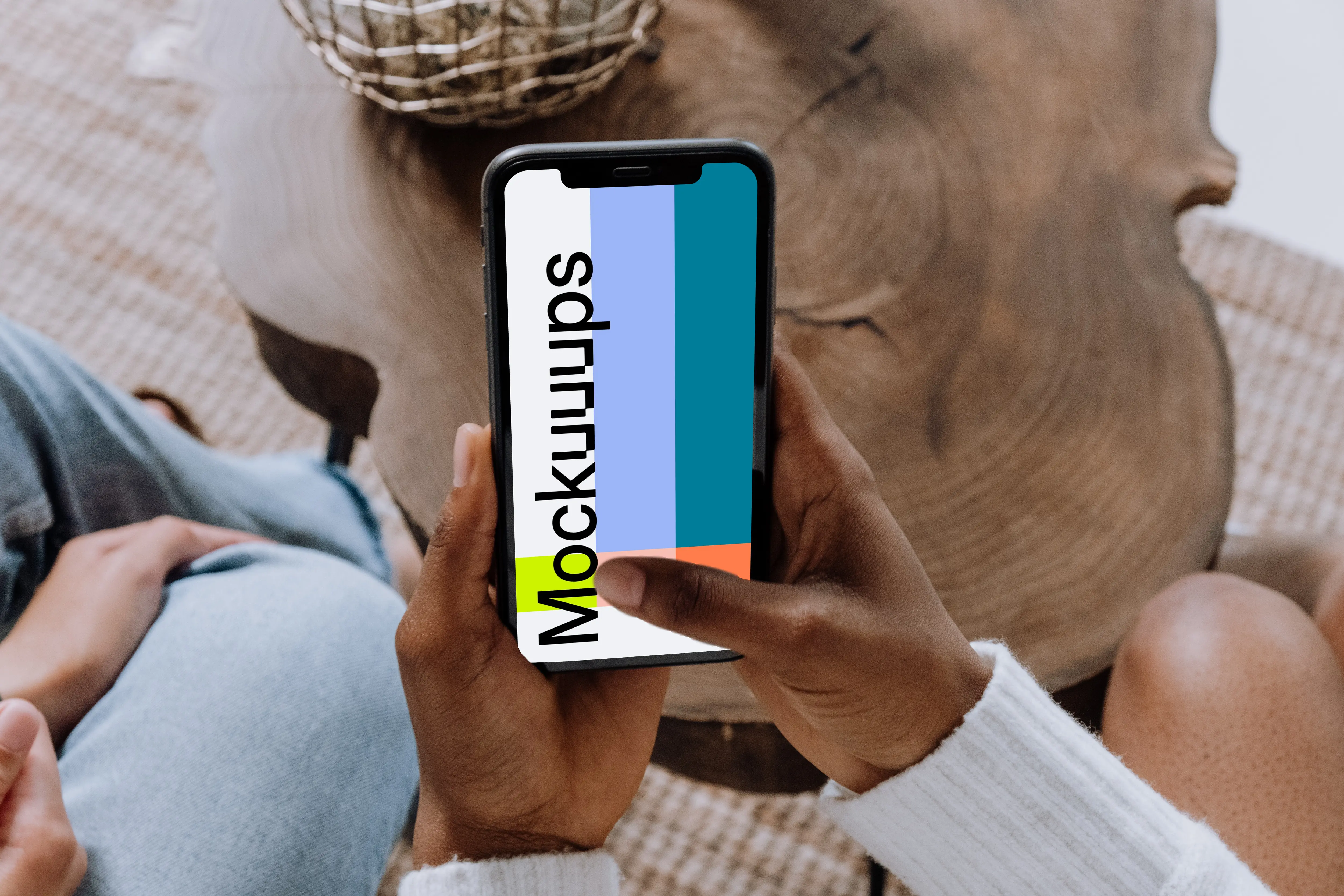 iPhone mockup held above a wooden table