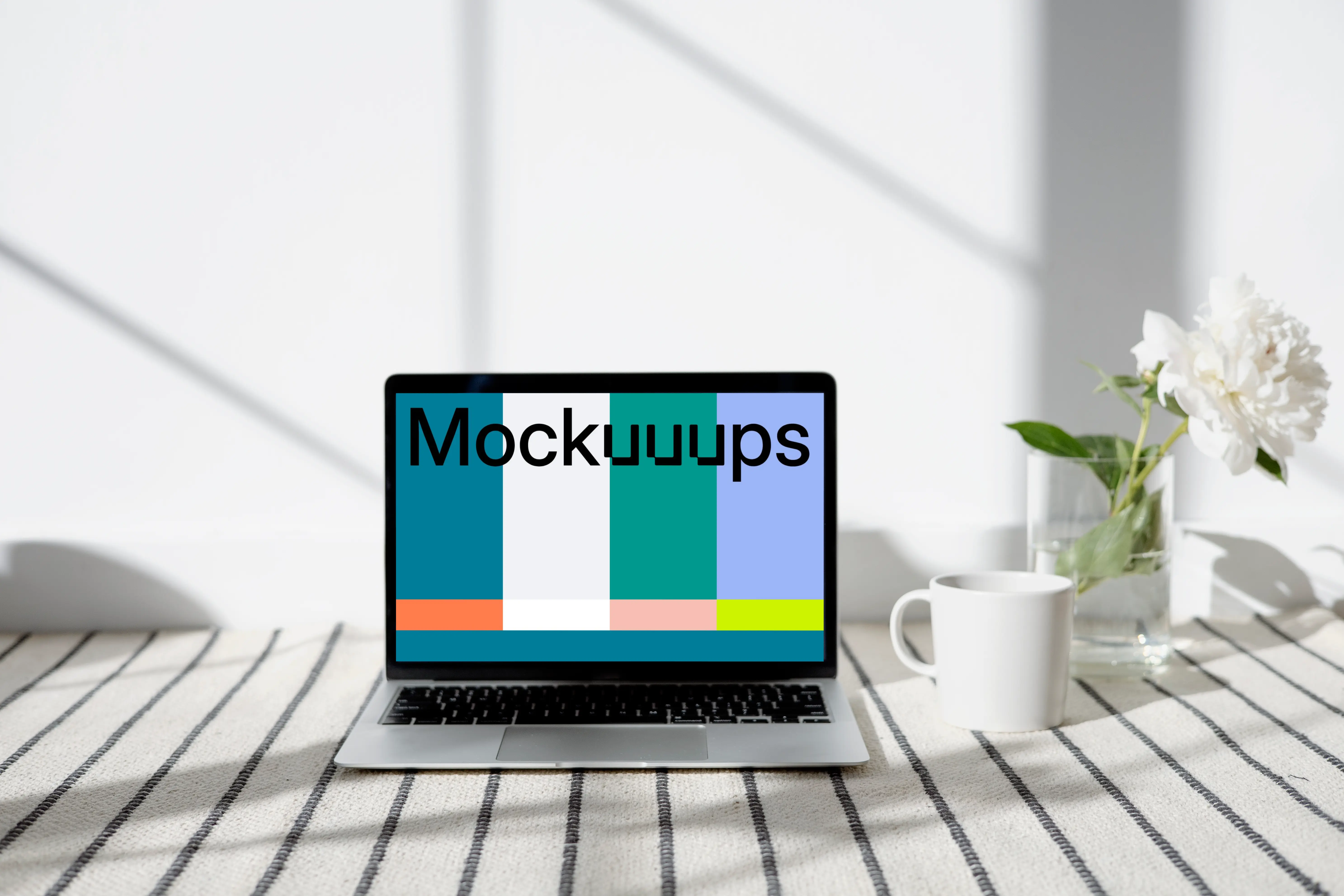 MacBook mockup on a patterned carpet with a cup at the side