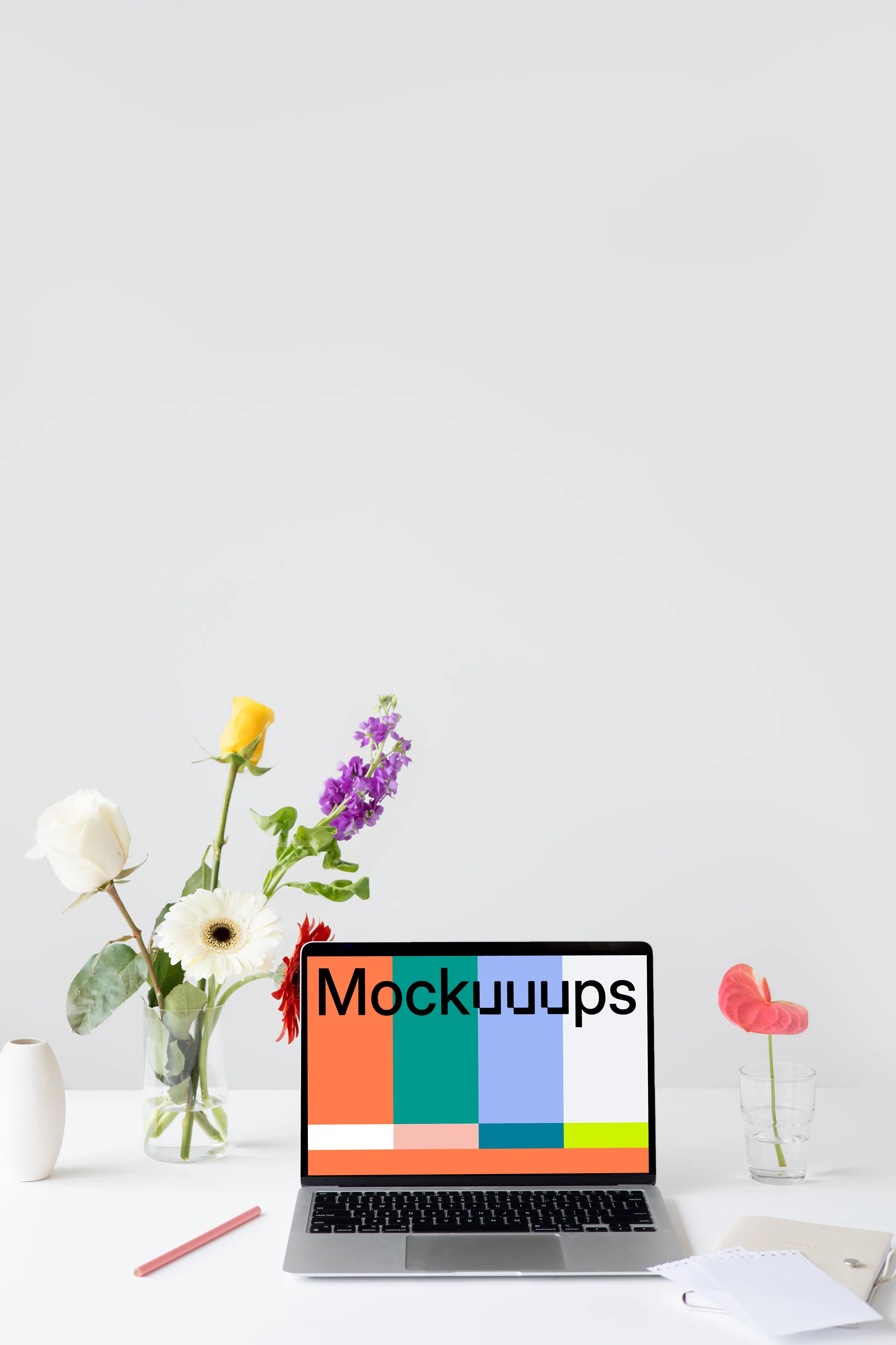 MacBook mockup on a table with flowers by the side