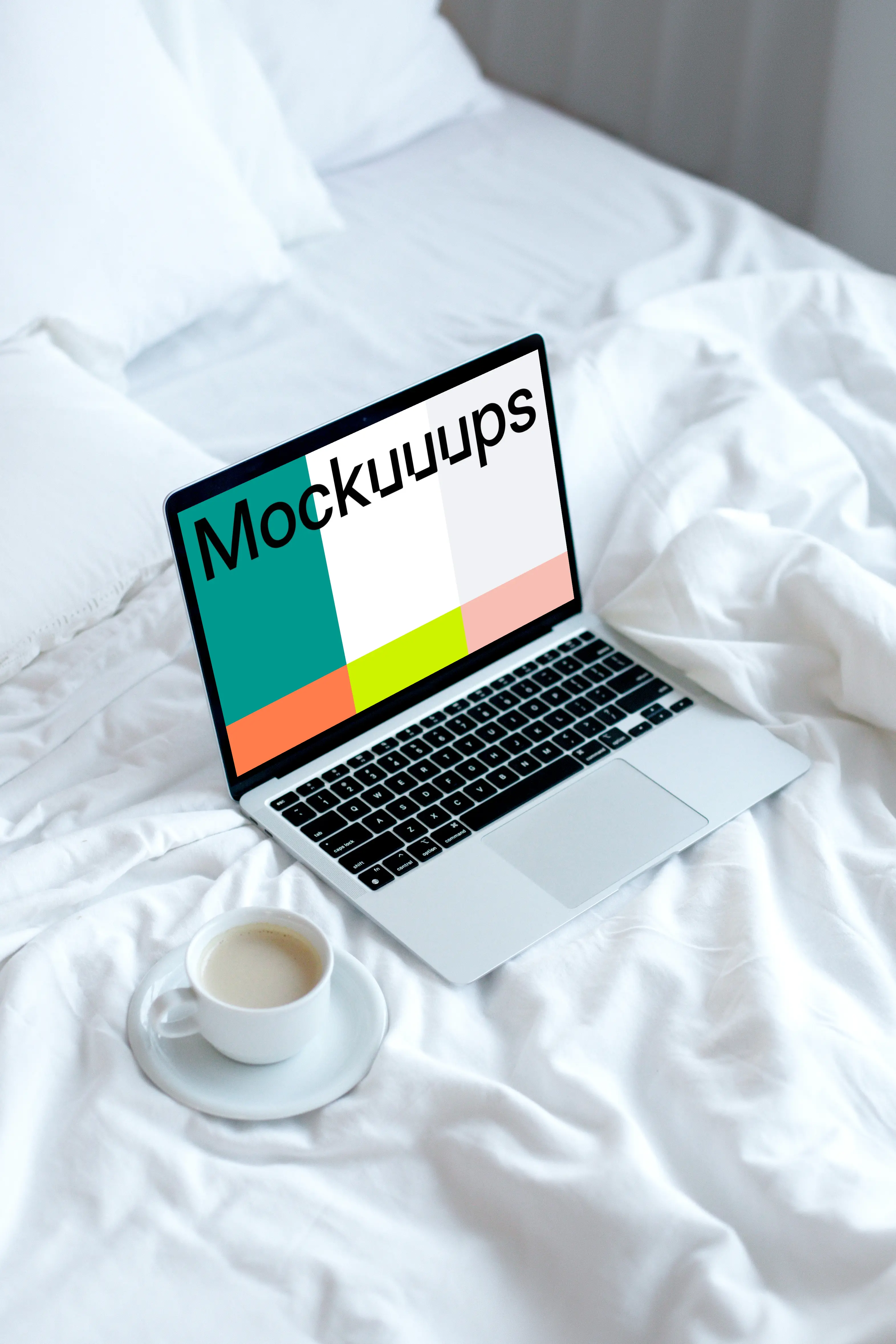 MacBook mockup on a white bed with coffee on a saucer