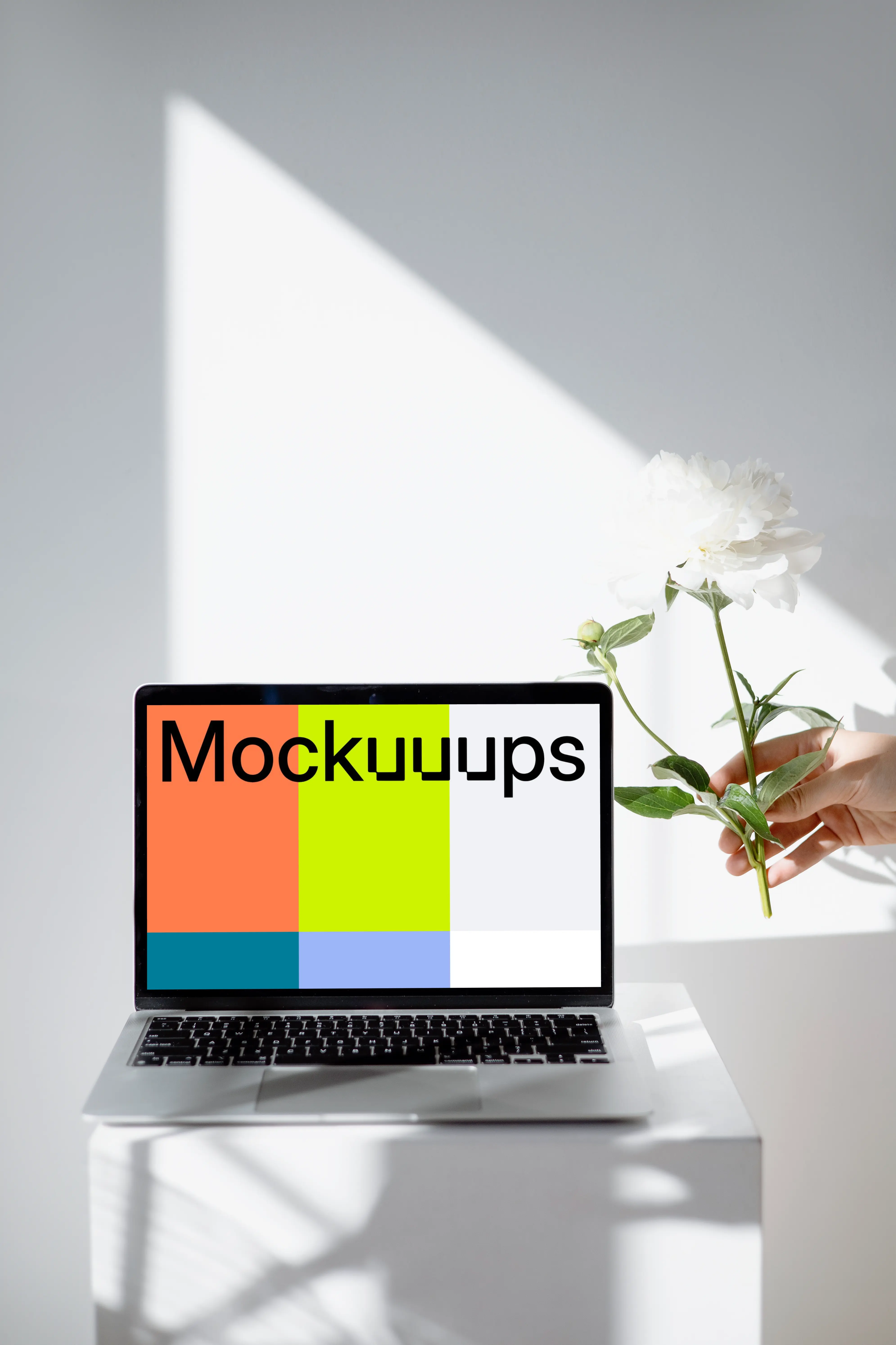 MacBook mockup on a white table close to the window