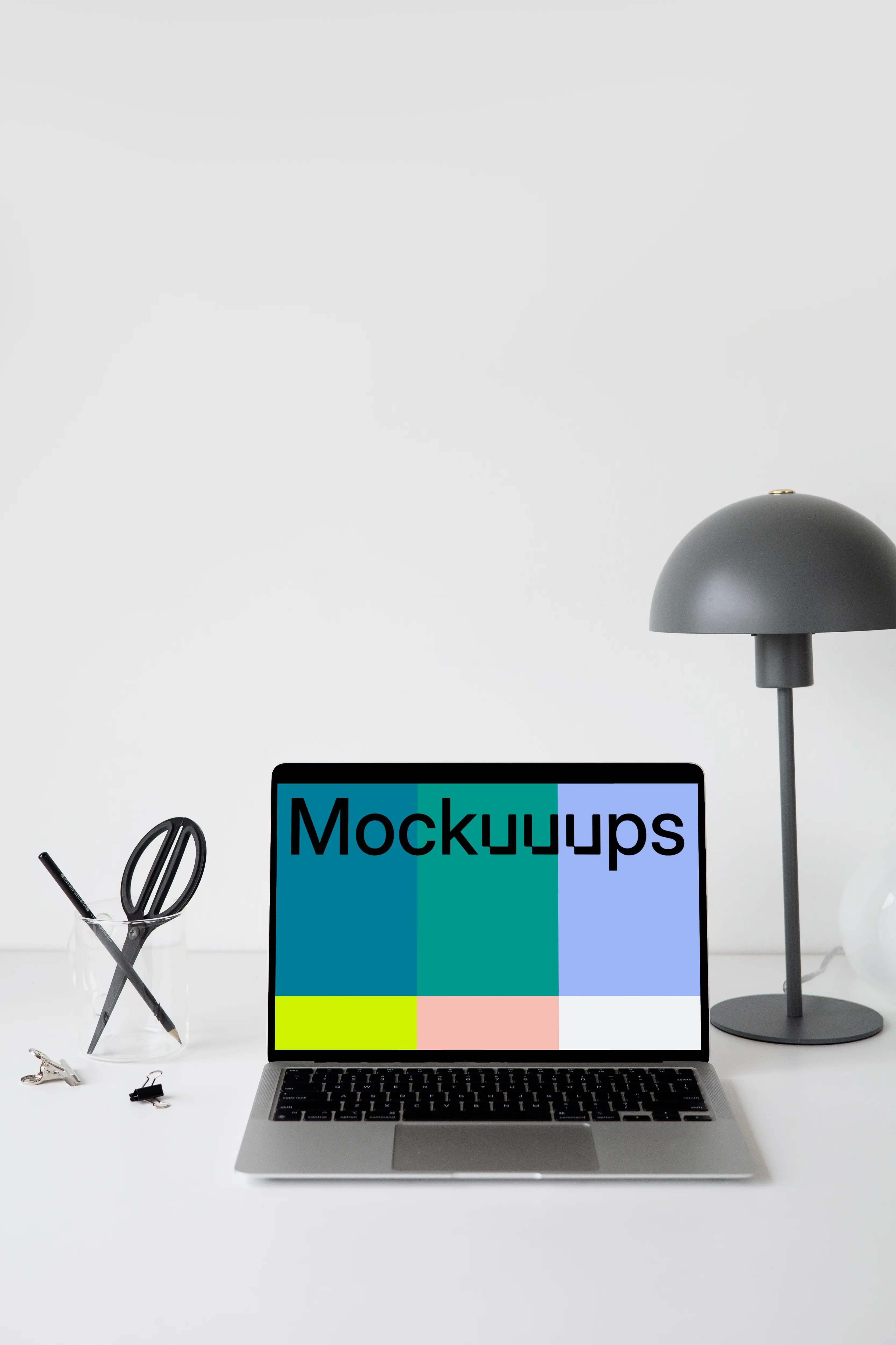 MacBook mockup on a white table with black table lamp at the side