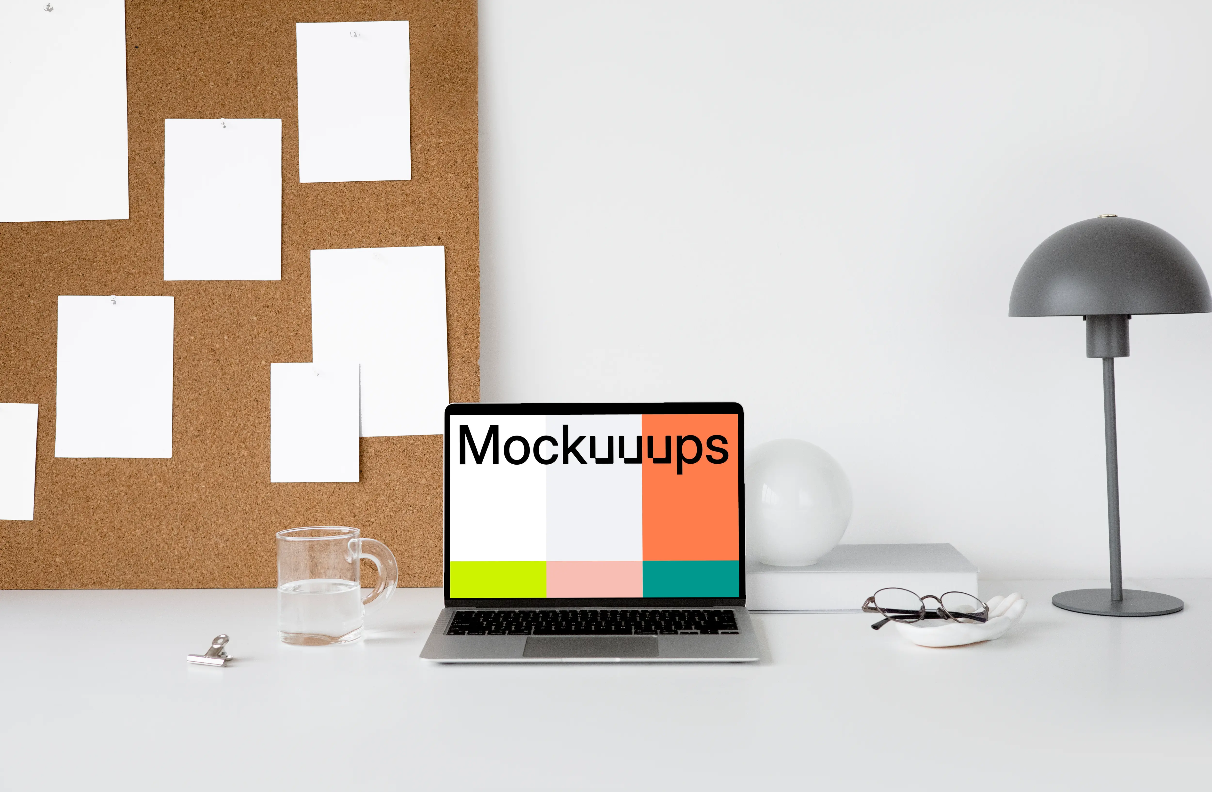 MacBook mockup on a white workstation table with task board at the side