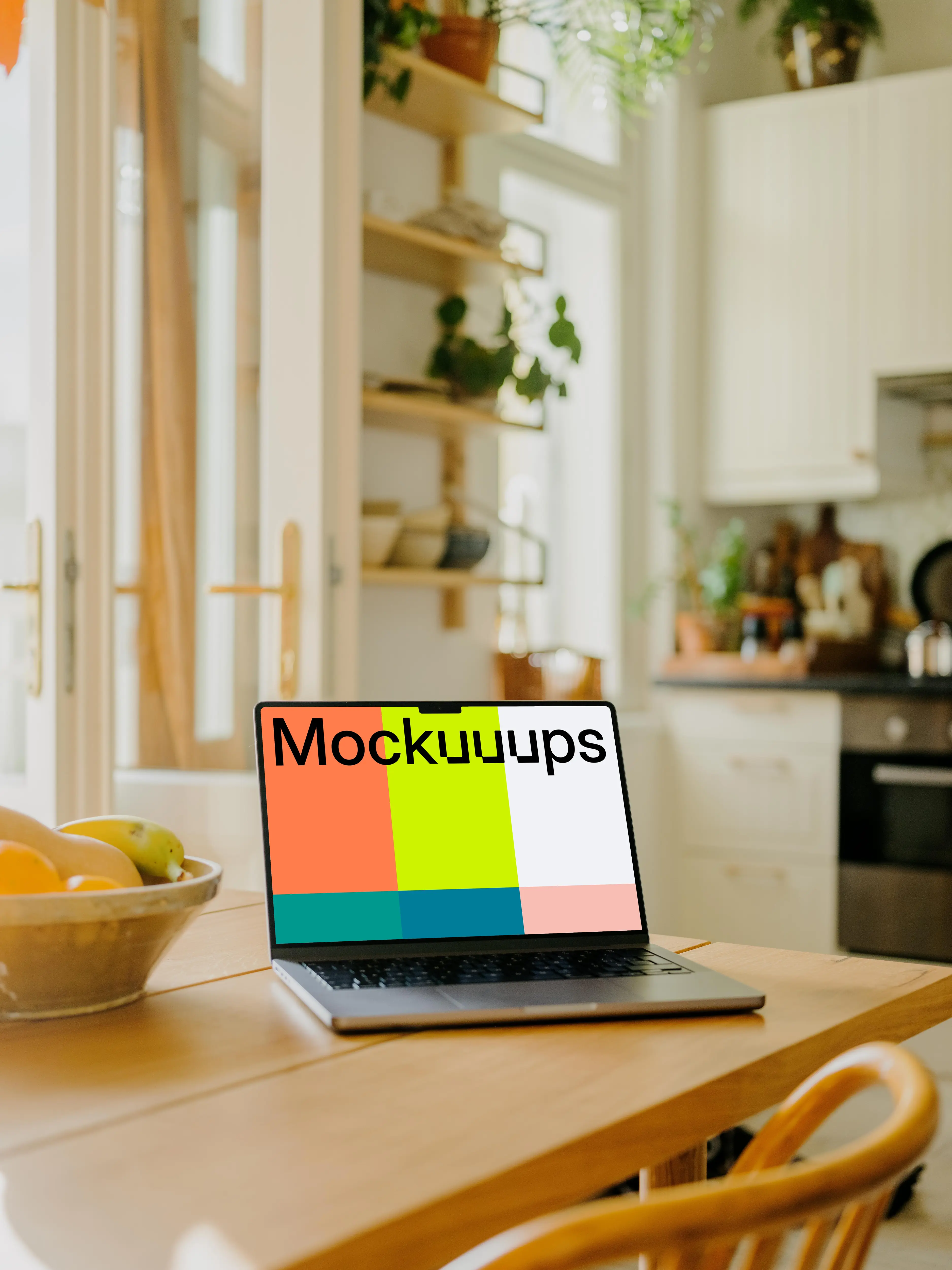 MacBook Pro mockup on a dining table beside a fruit basket